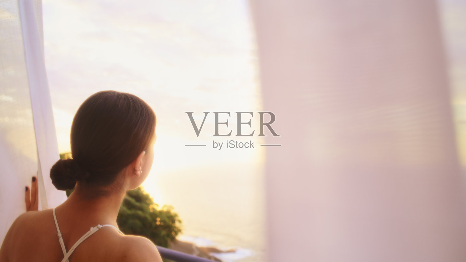 妩媚的女人躲在透明的窗帘后面照片摄影图片