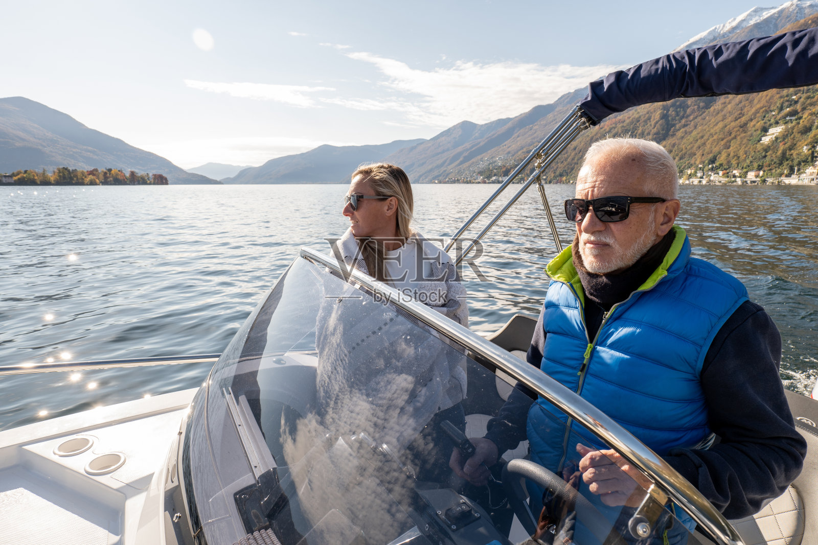 年轻男人和年长的男人在豪华游艇上欣赏秋日湖景照片摄影图片