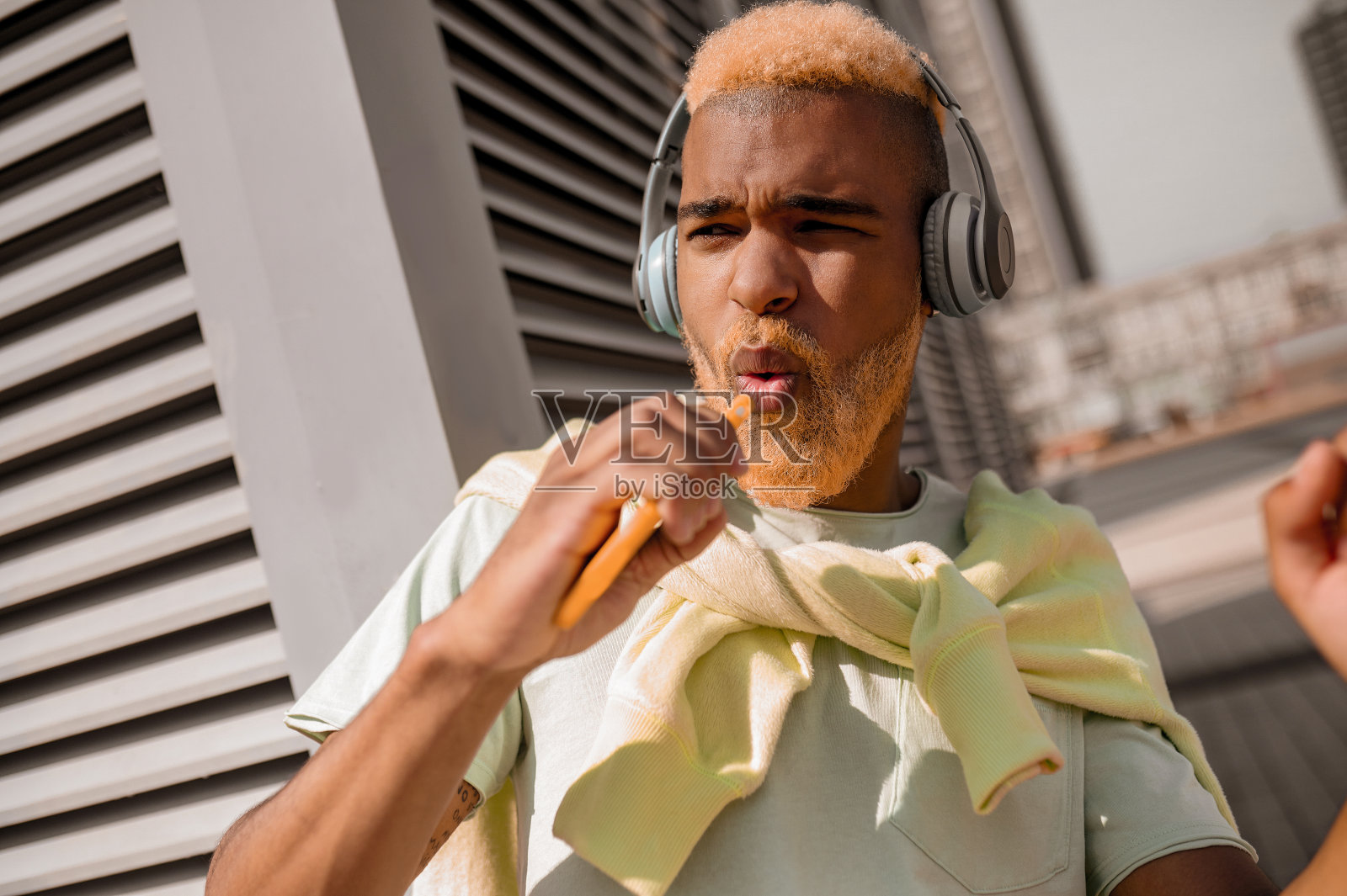 一个年轻人戴着耳机听音乐，看起来很享受照片摄影图片