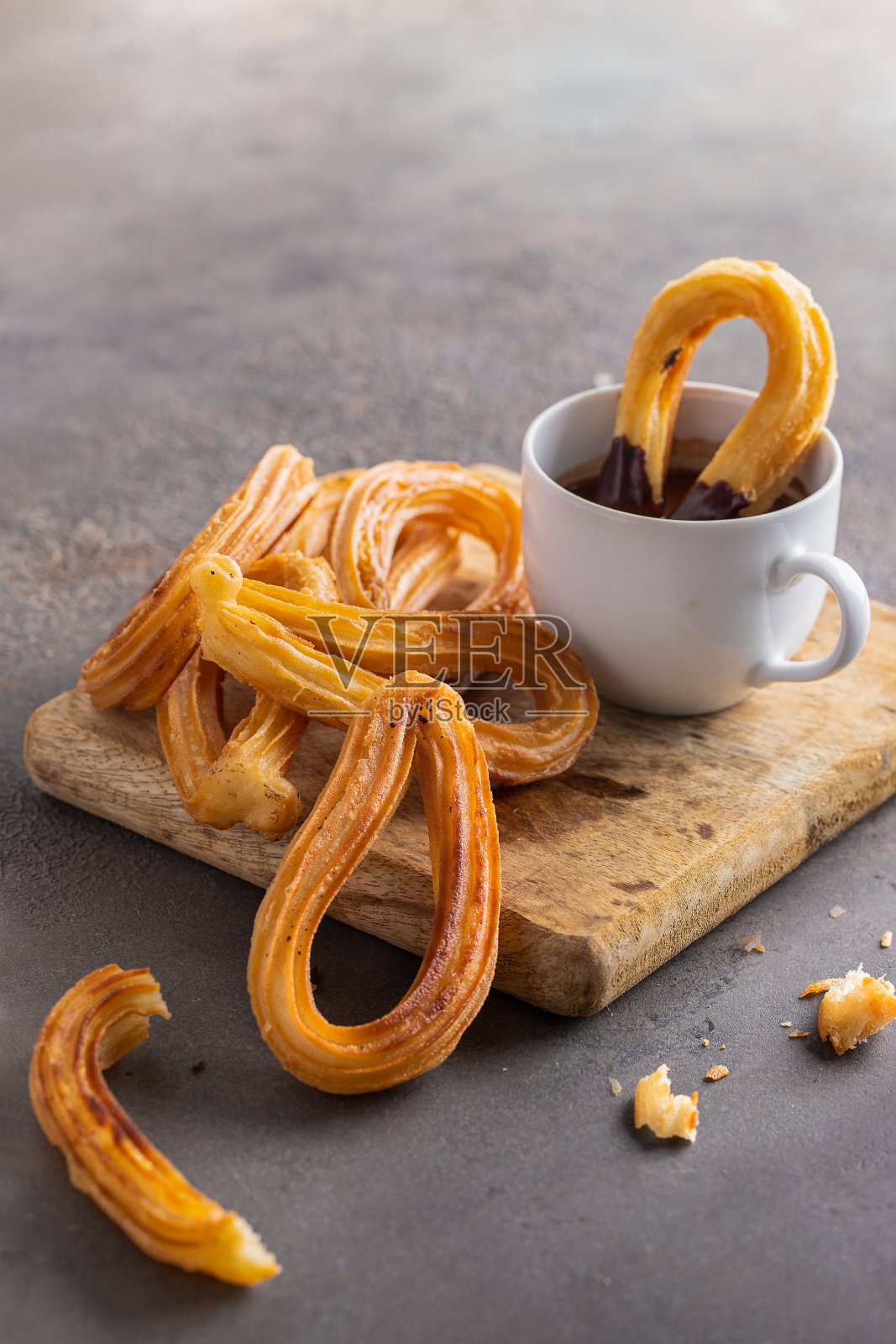 油条，典型的西班牙小吃是一种油炸面团。西班牙油条是一种经典的西班牙早餐搭配热巧克力照片摄影图片