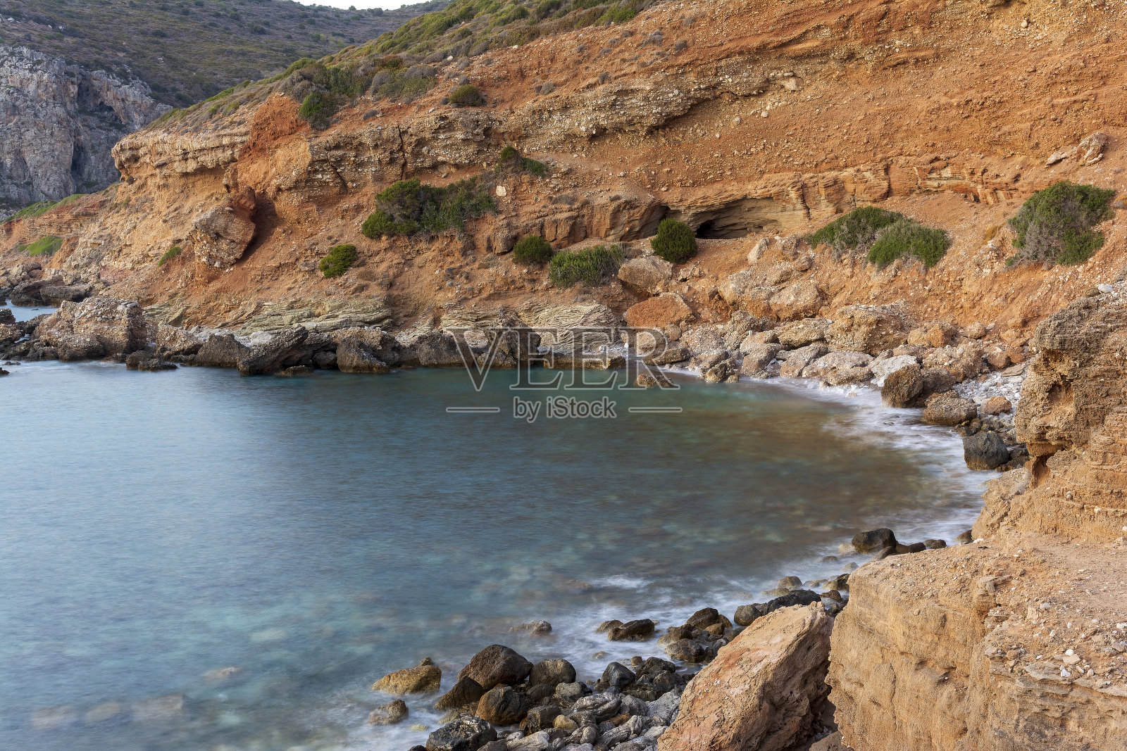 希腊基西拉岛的石质海滩，海水碧绿照片摄影图片