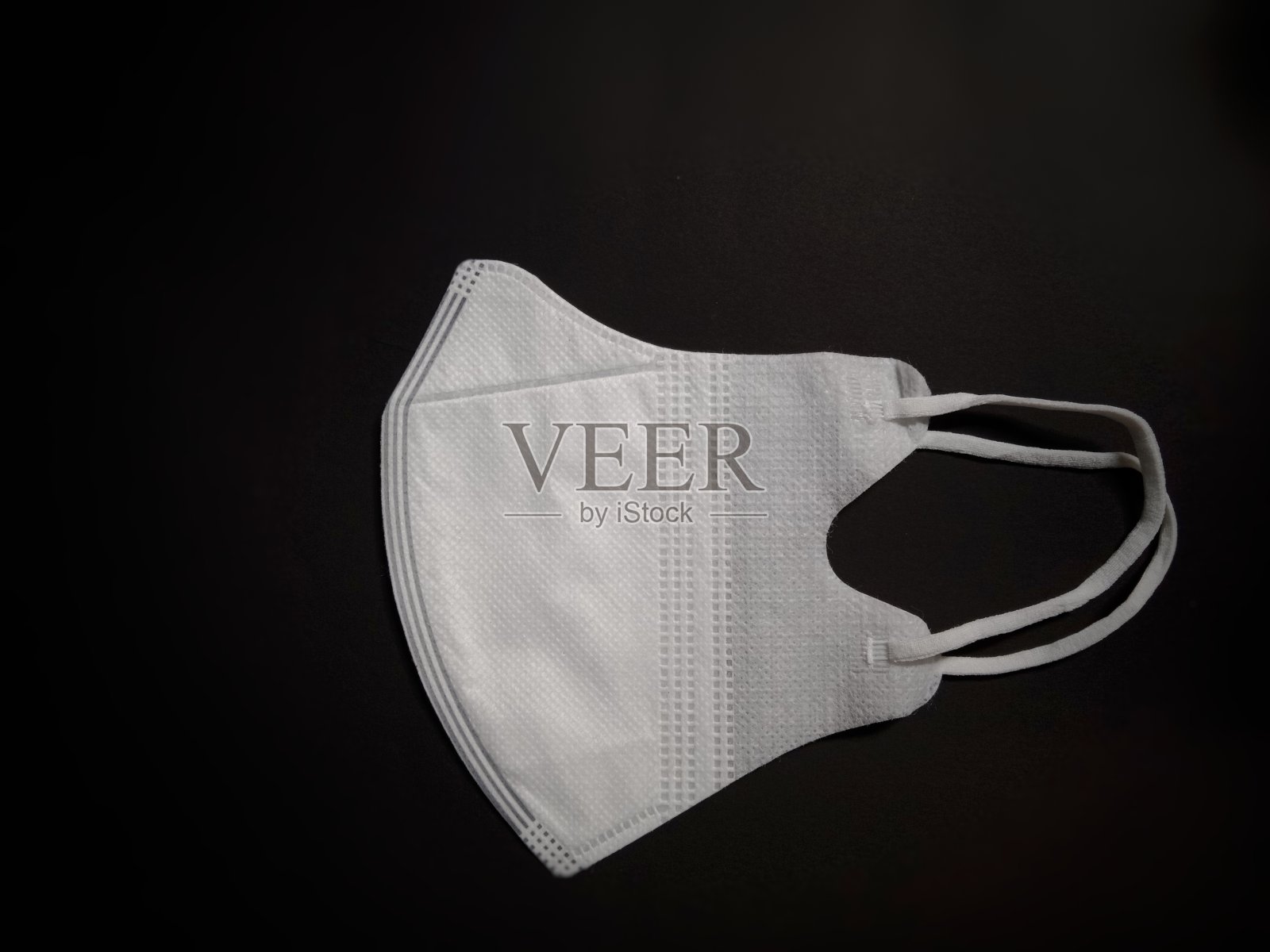 黑色背景的白色医用口罩照片摄影图片