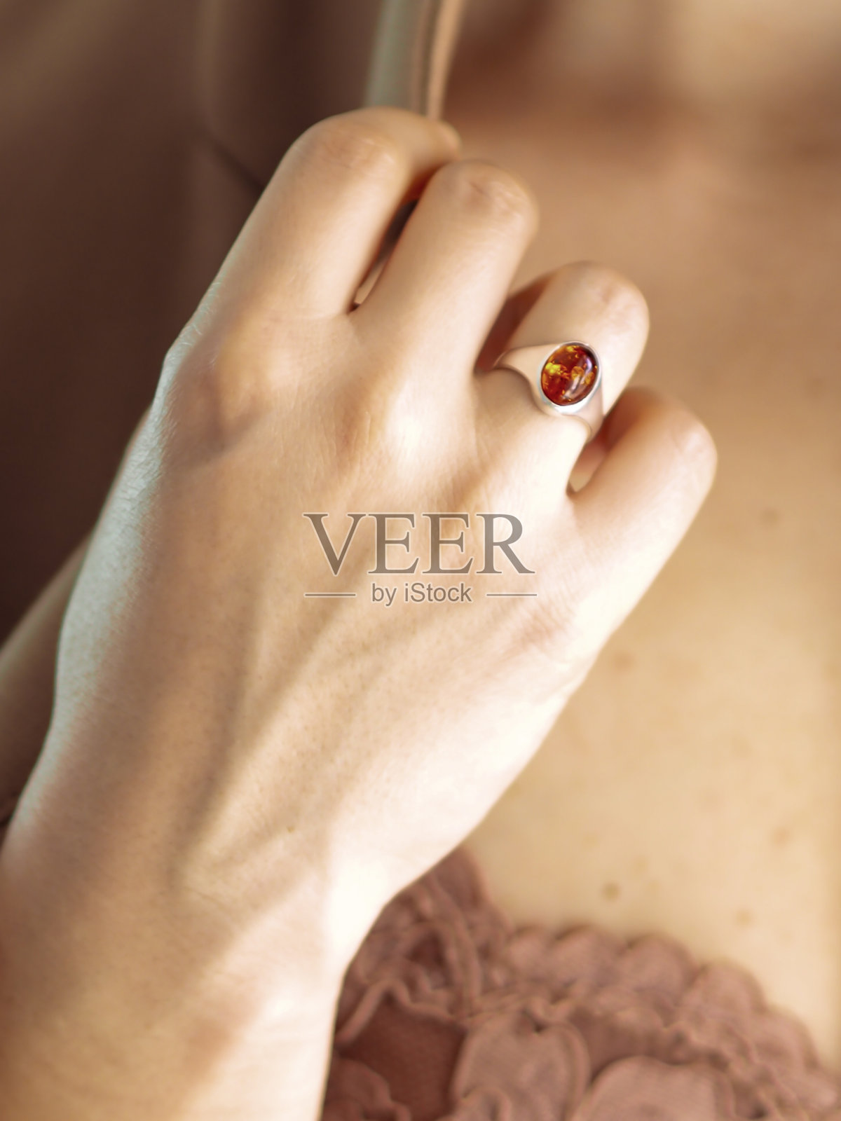 一个女人手上戴着琥珀戒指照片摄影图片