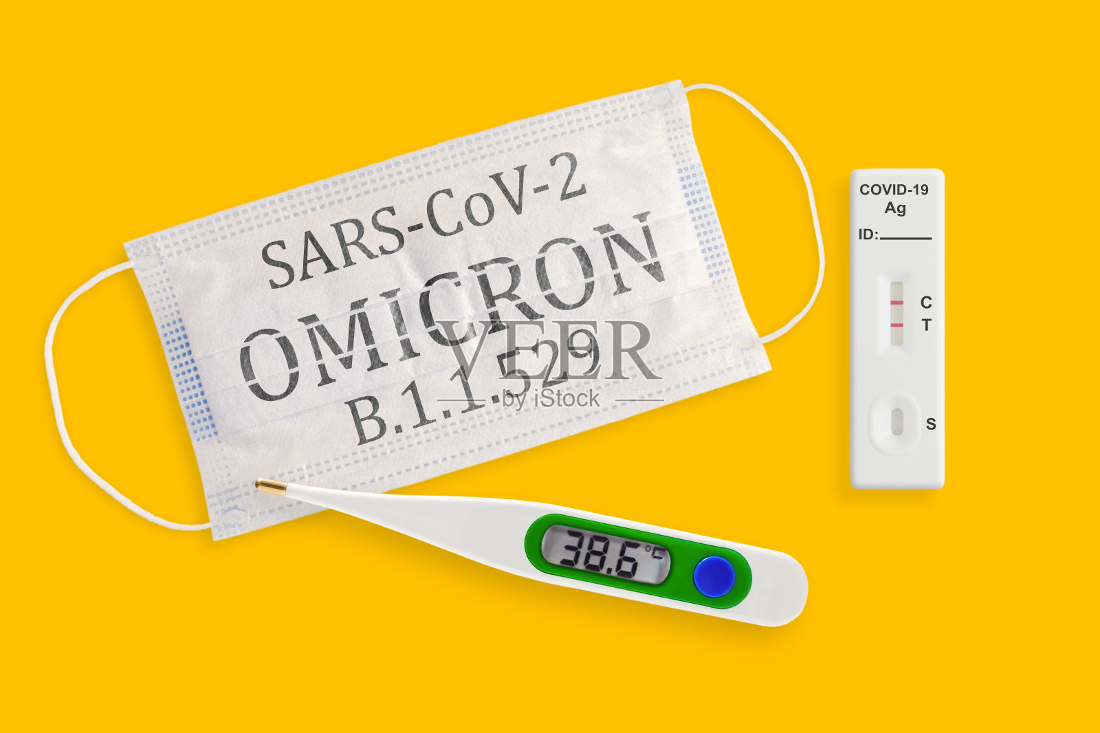快速抗原检测试剂盒，拭子COVID - 19检测呈阳性。黄色背景的口罩和温度计照片摄影图片
