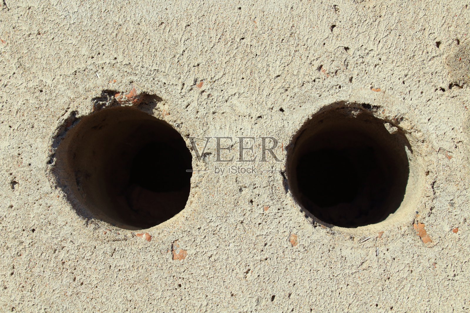 有两个洞的灰色砖。特写镜头。背景。纹理。照片摄影图片