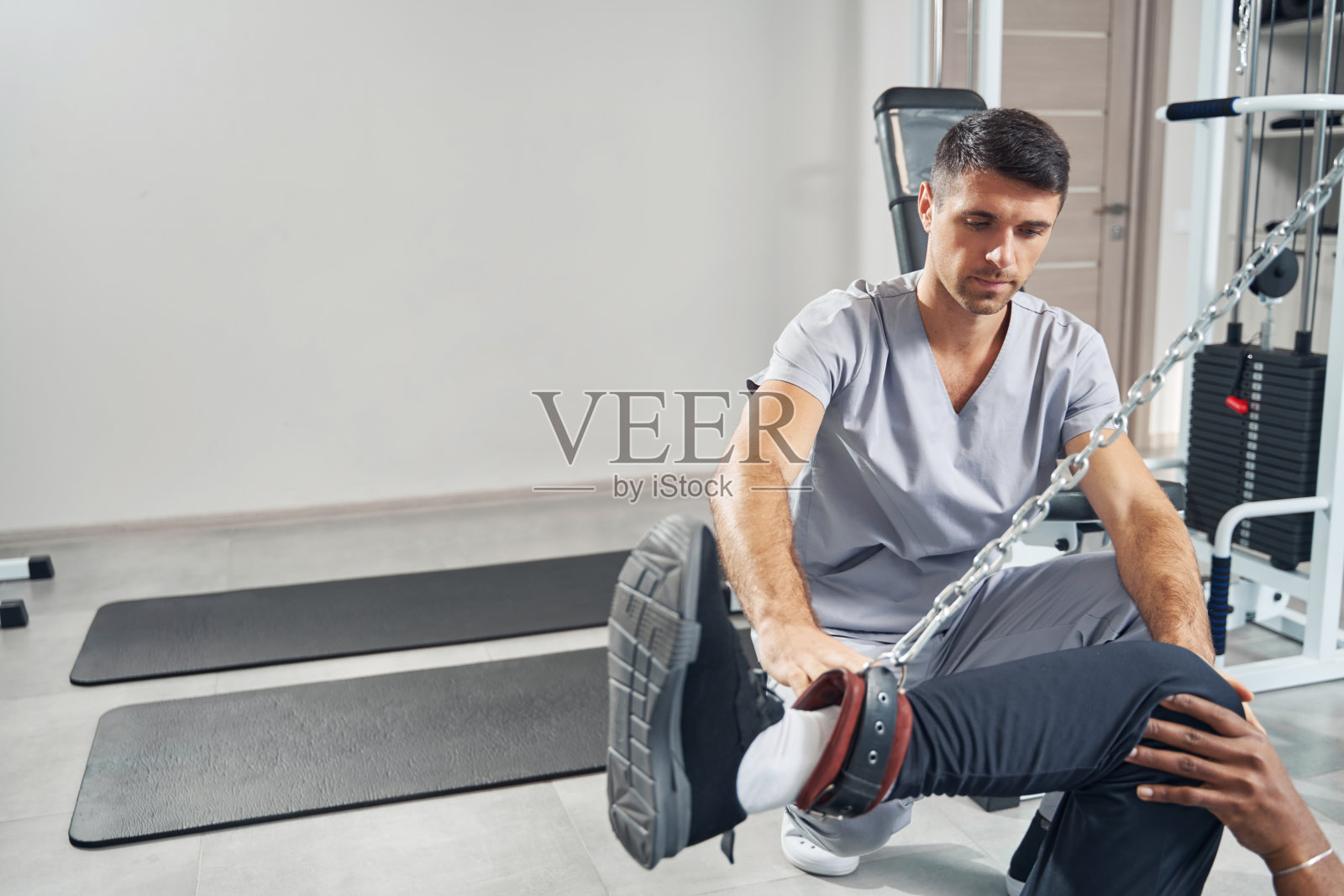 医生使用电缆机进行病人康复治疗照片摄影图片