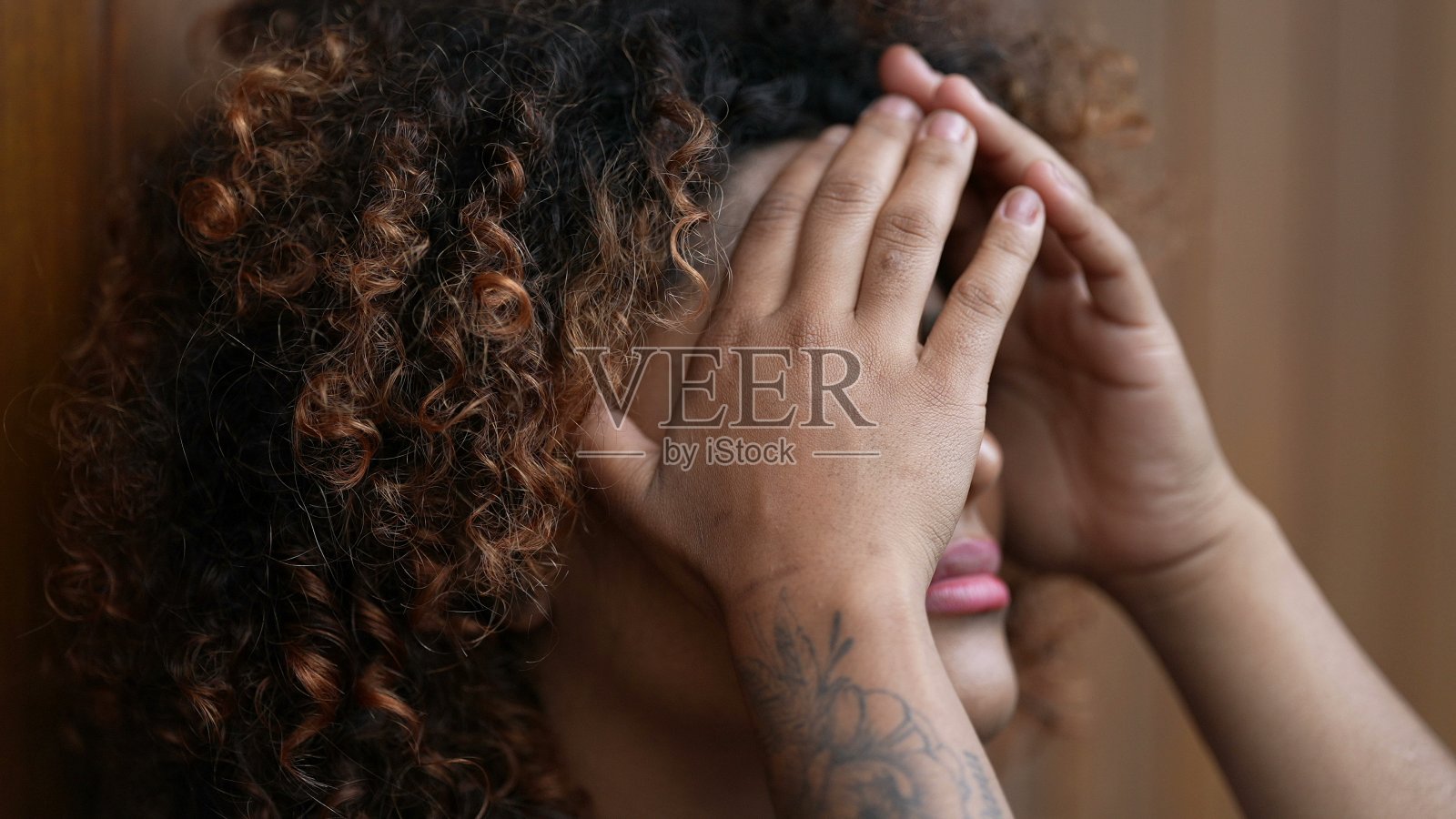 绝望的黑人妇女用双手捂着脸，绝望和孤独照片摄影图片