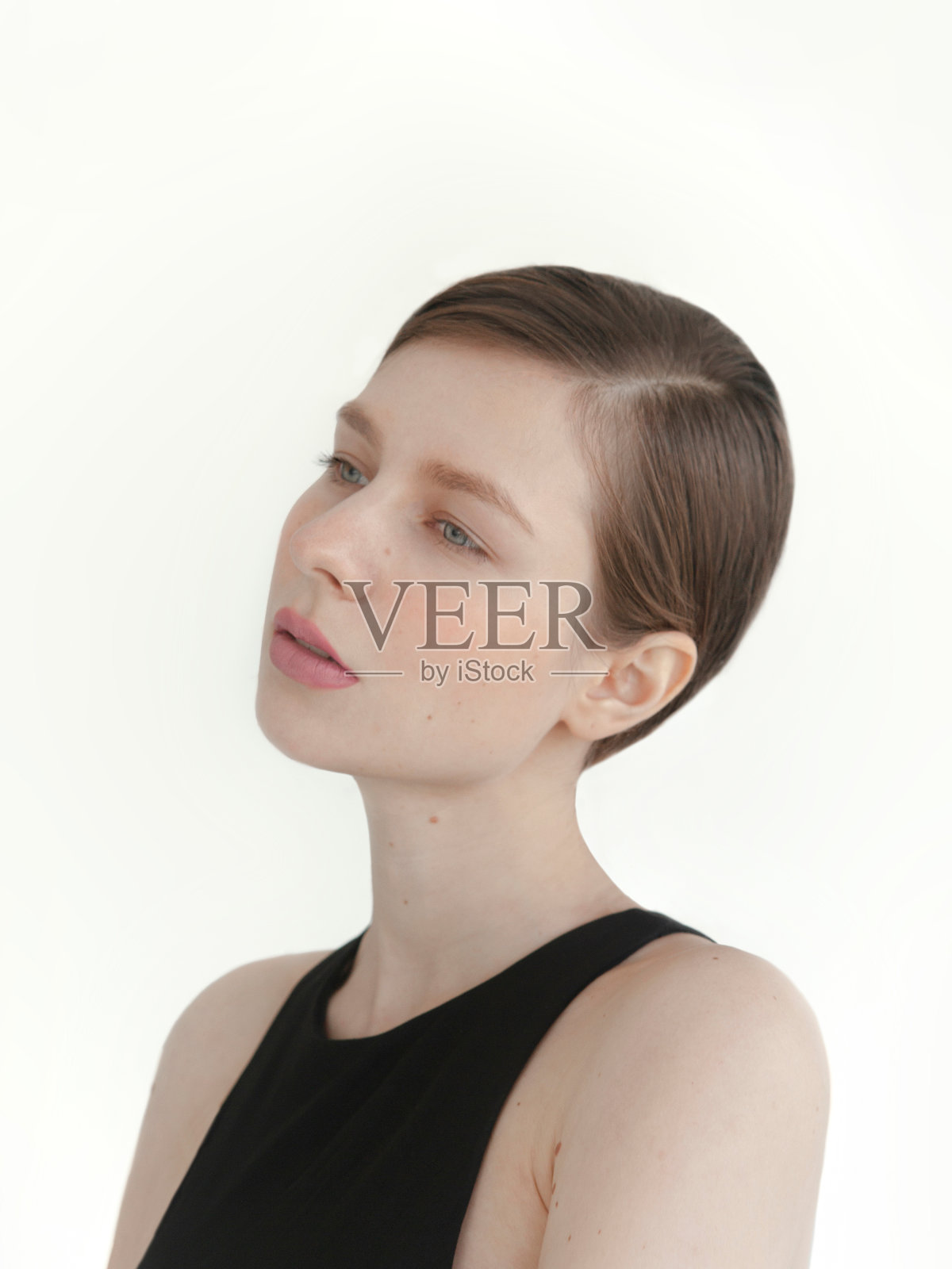 美丽的黑发年轻女子与发光的化妆穿着黑色的顶部在白色背景时装模特近距离拍摄照片摄影图片