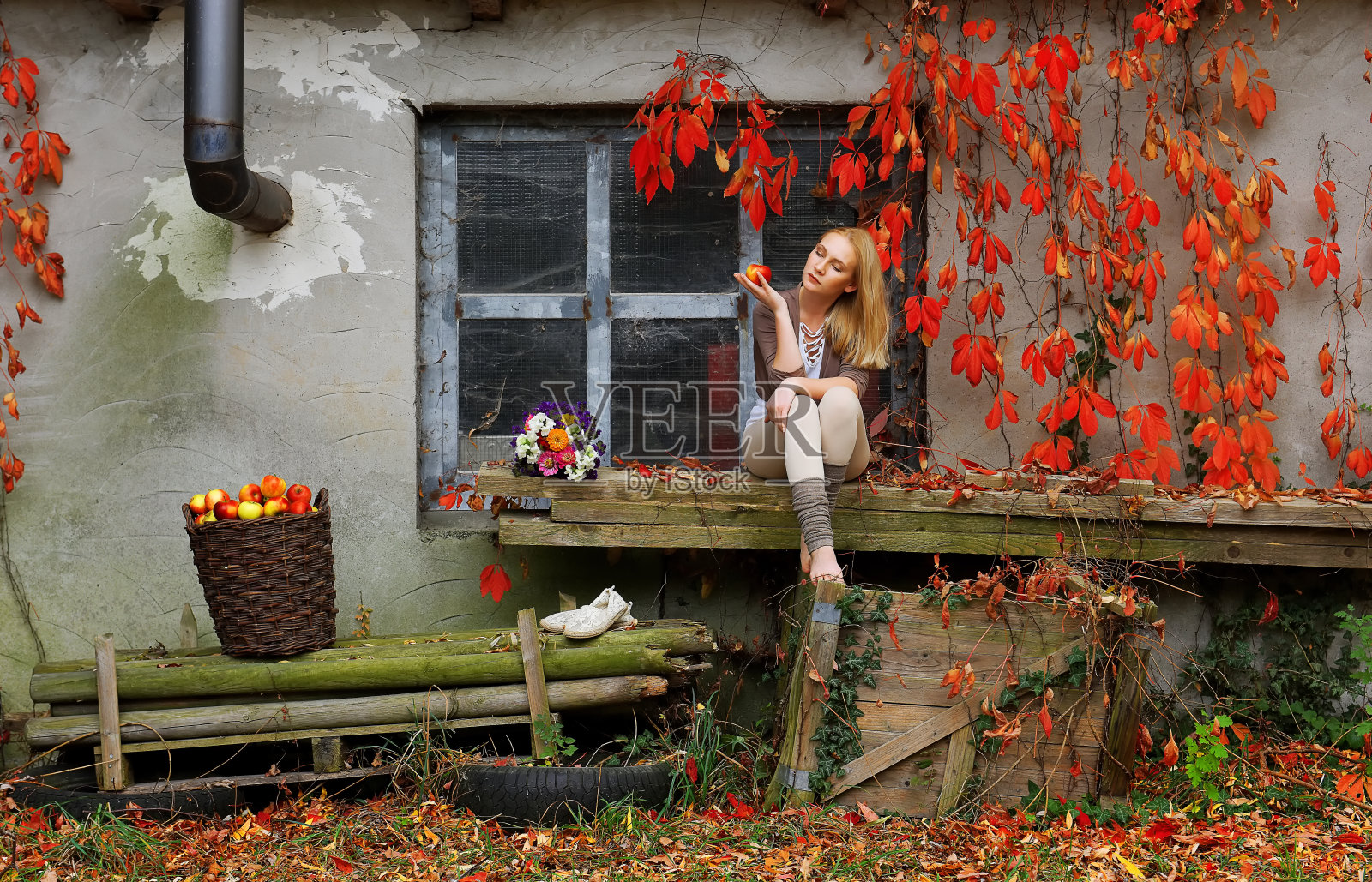 一位年轻女子在秋天放松身心，手里拿着一个苹果照片摄影图片