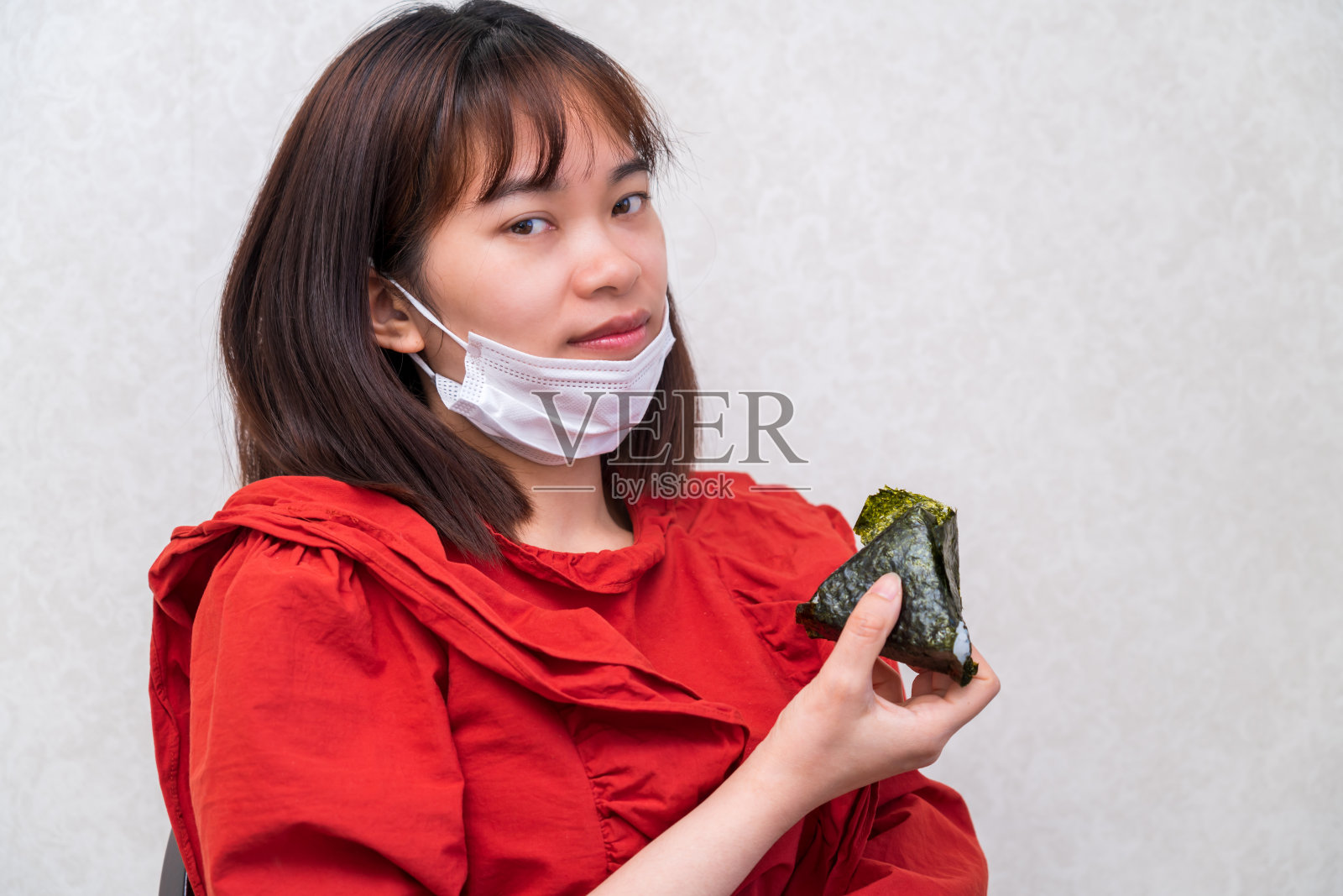 年轻女子戴着口罩吃饭。新冠肺炎的新常态照片摄影图片