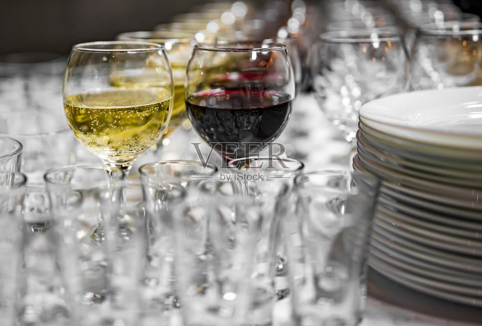 桌上放着盛着红酒和白酒的玻璃杯照片摄影图片