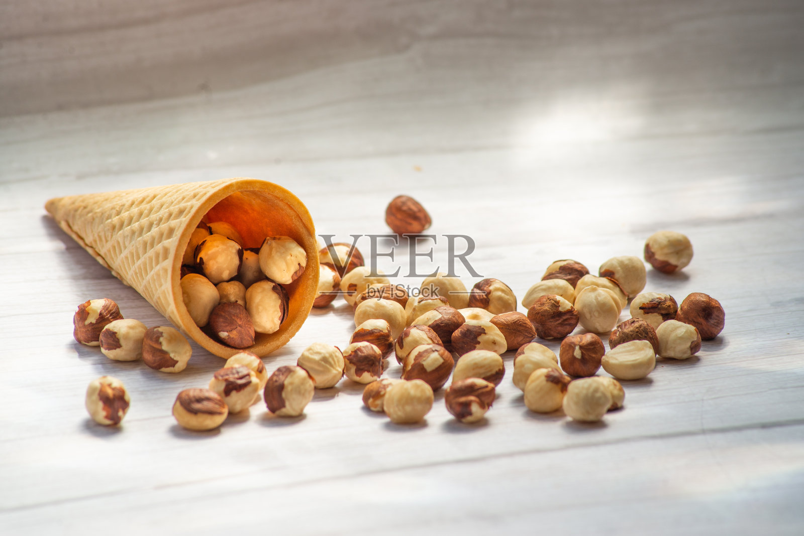 健康的食物混合坚果，干果，花生，榛子，核桃，梅干，杏干在粗麻布木制背景上的特写照片摄影图片