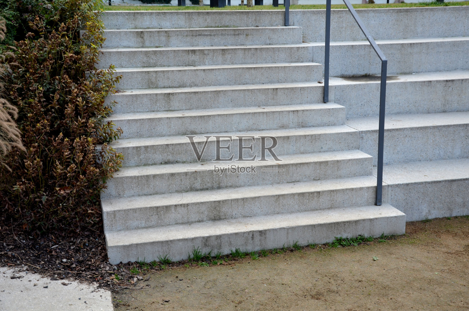 灰色整体混凝土公园长凳由圆形石头形状的混凝土制成木制楼梯长凳楼梯照明金属栏杆楼梯上黑色格子，花坛，照片摄影图片