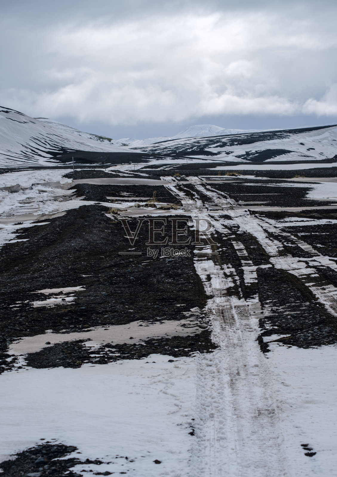 冰岛，秋天，冰雪覆盖下的五彩缤纷的山地。前景是火山砂的熔岩场。照片摄影图片