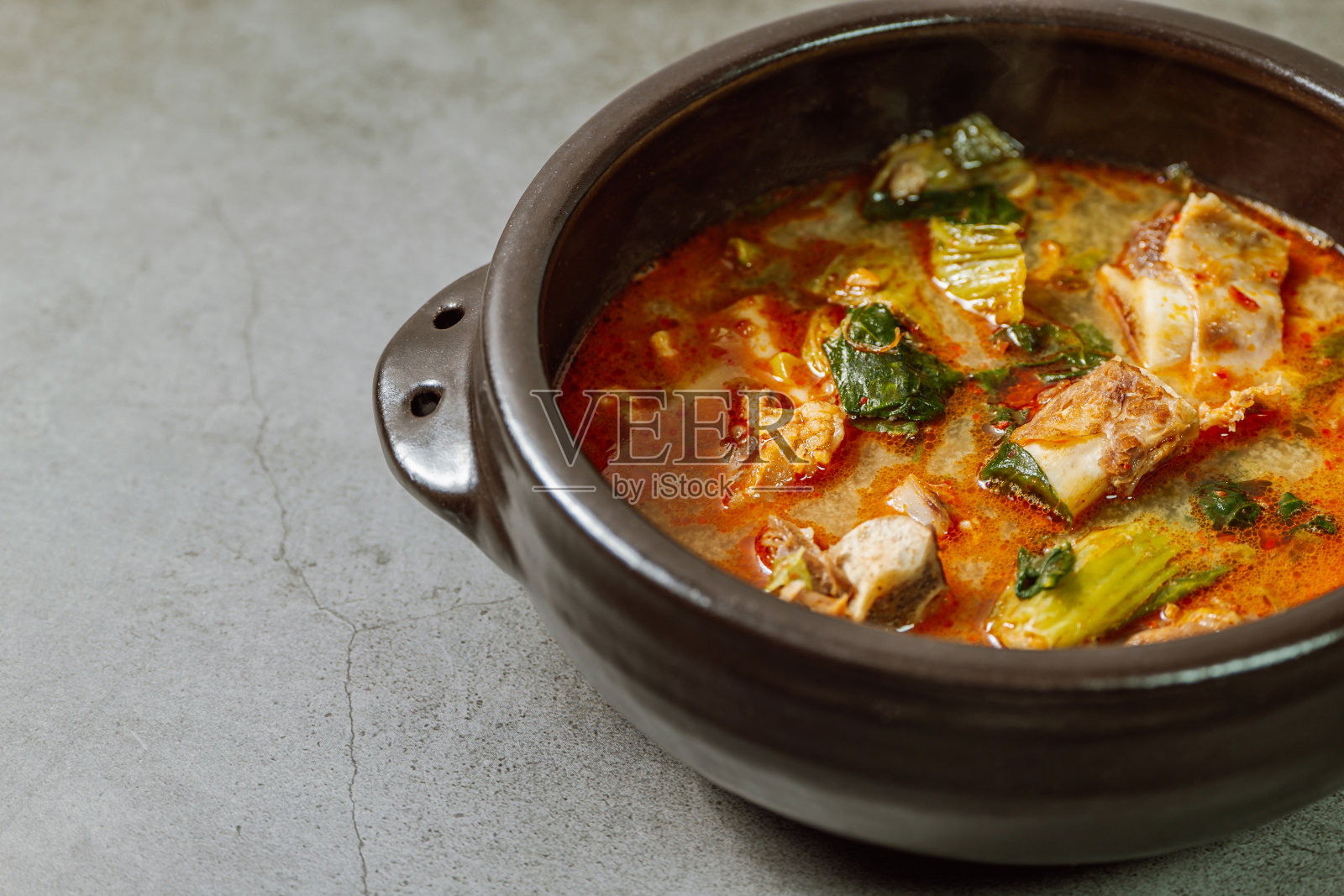 韩国大白菜排骨汤:白菜叶在牛肉排骨汤中慢慢炖，用大酱(大酱)调味。青菜是指卷心菜或其他带叶蔬菜的绿色外层。照片摄影图片