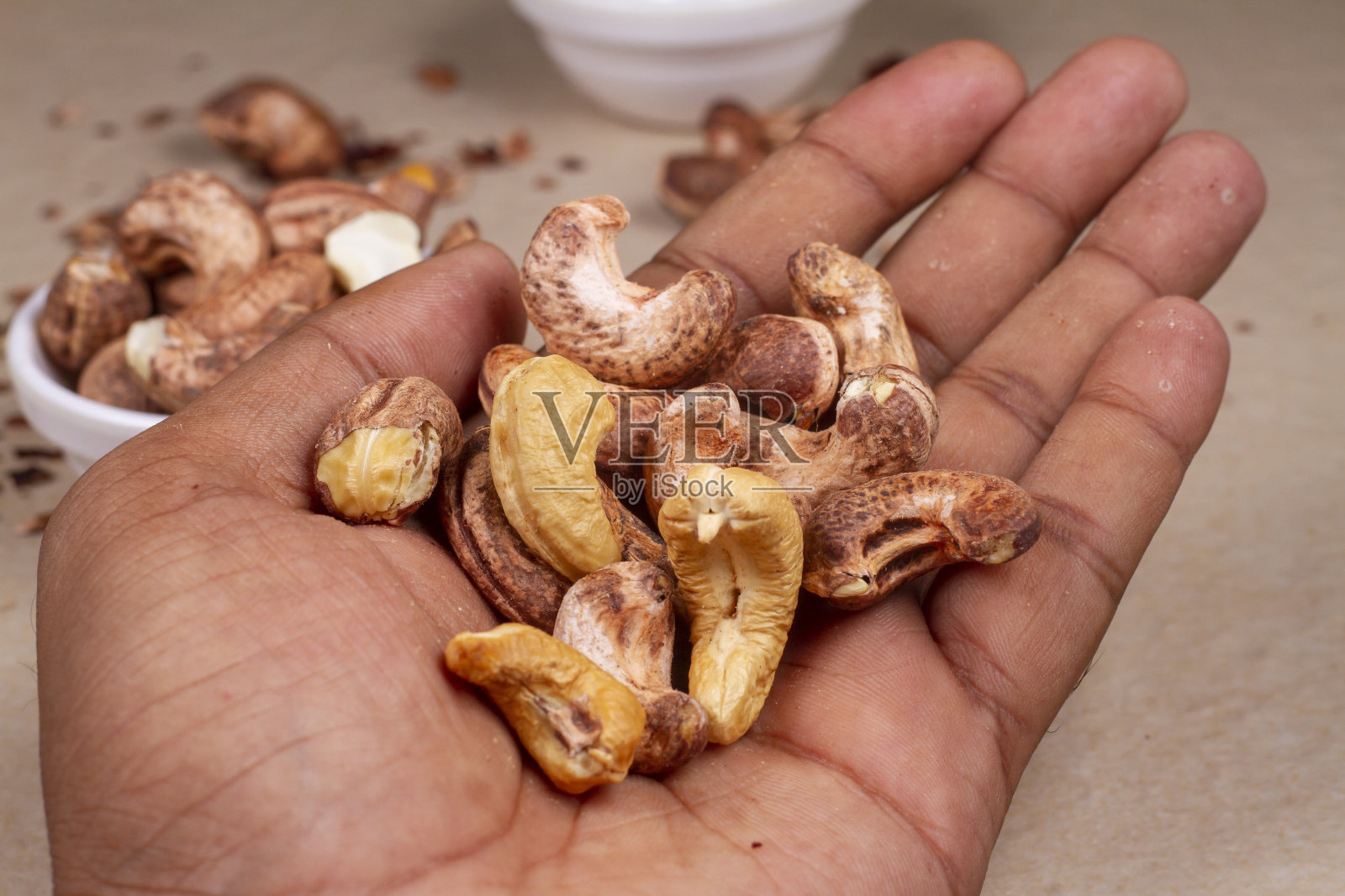 烤腰果在手轻背景隔离。照片摄影图片
