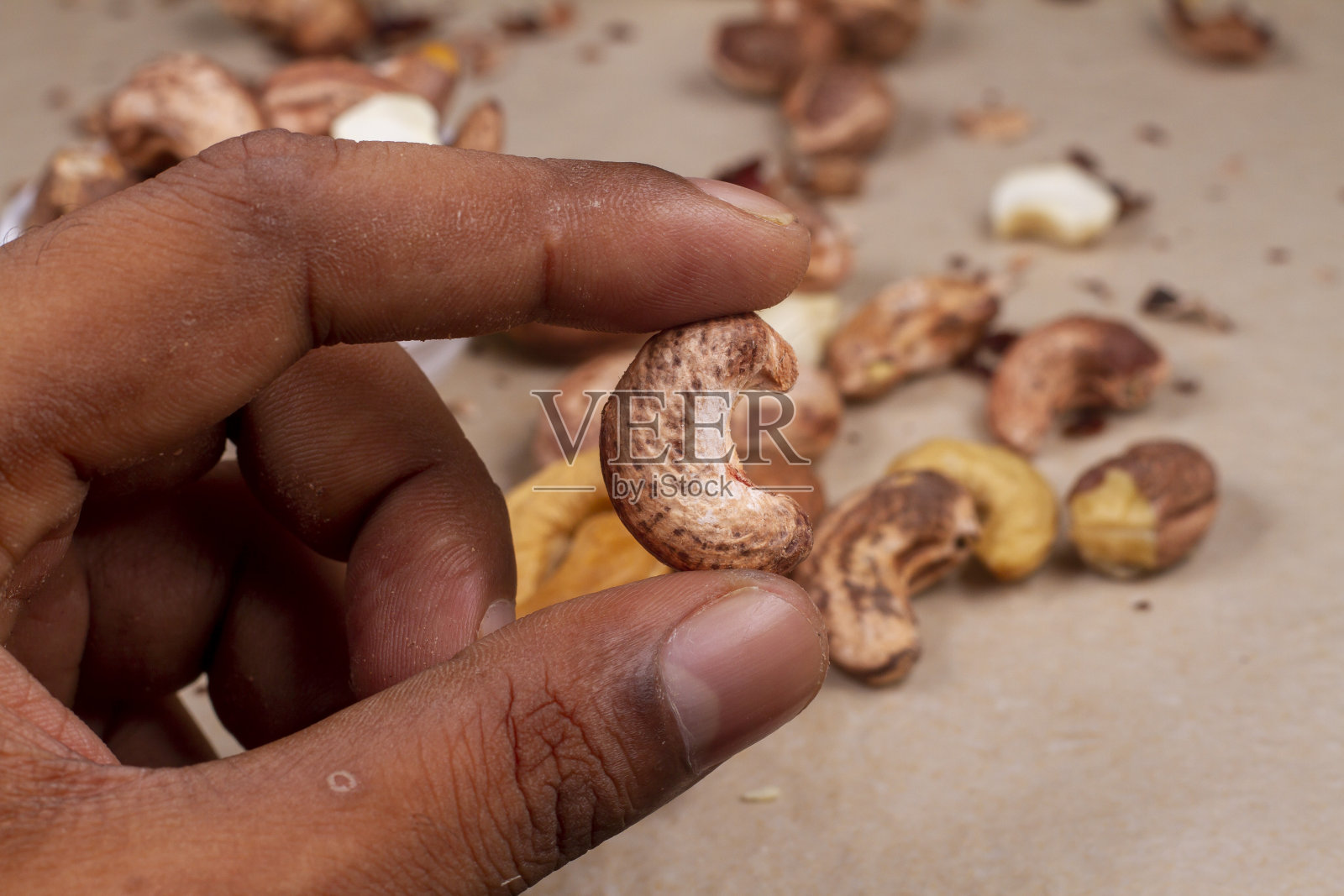 烤腰果在手轻背景隔离。照片摄影图片