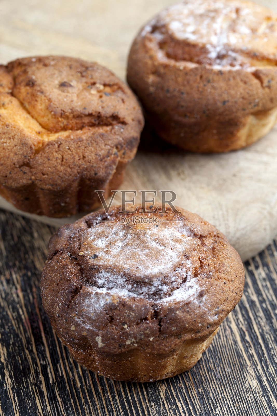木桌上放着新鲜的白干酪纸杯蛋糕照片摄影图片