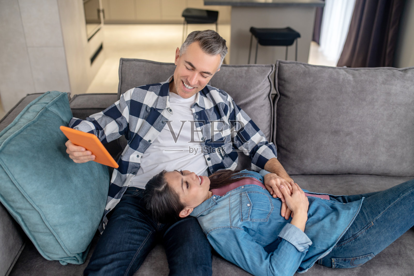 男人用平板电脑看着躺在床上的妻子的俯视图照片摄影图片