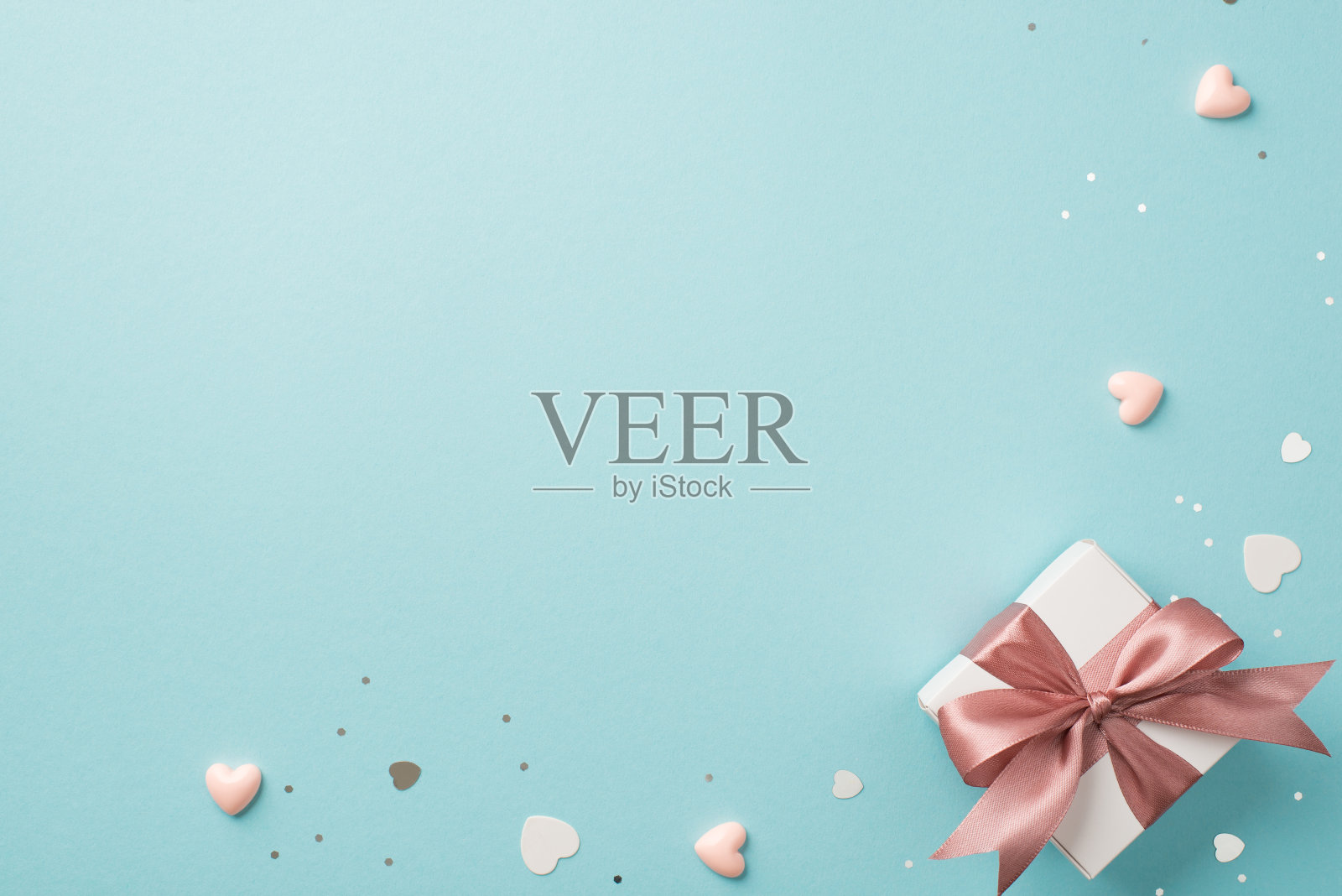 顶视图照片的情人节装饰白色礼品盒与粉红色蝴蝶结心纸屑和闪光在孤立的柔和的蓝色背景copyspace照片摄影图片