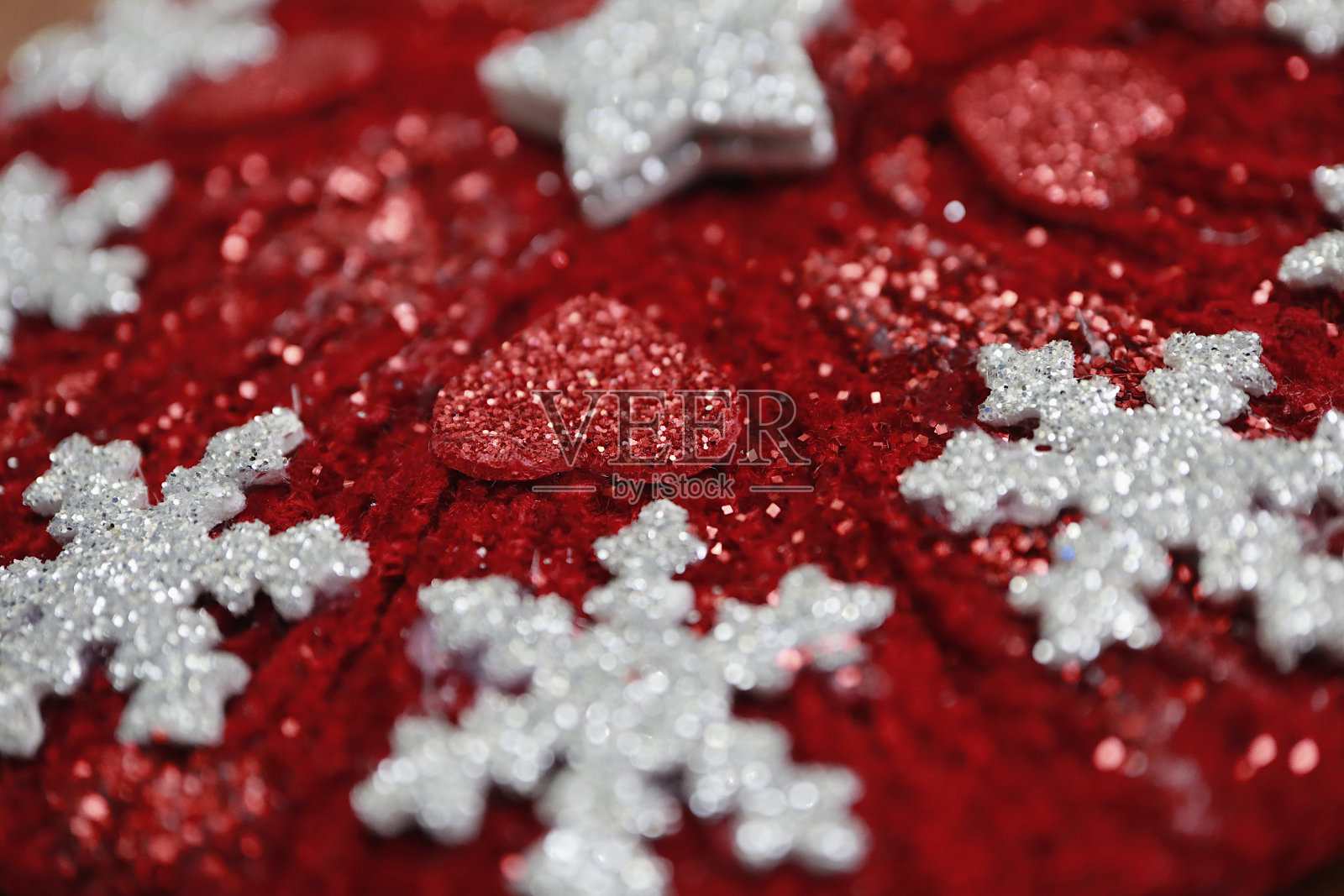 模糊特写的手工圣诞装饰与红色羊毛和闪光的eva gum小心脏，星星和雪花照片摄影图片