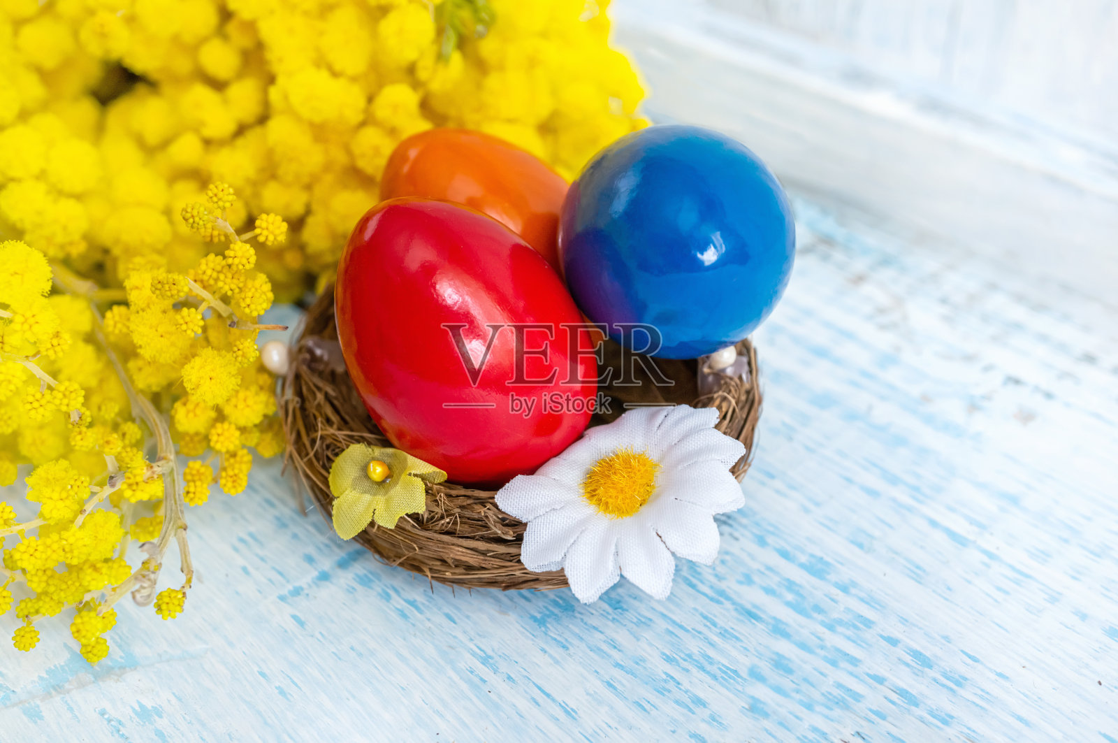 五彩缤纷的复活节彩蛋和一束含羞草。乡村风格的复活节装饰。复活节问候的水平背景。本空间照片摄影图片