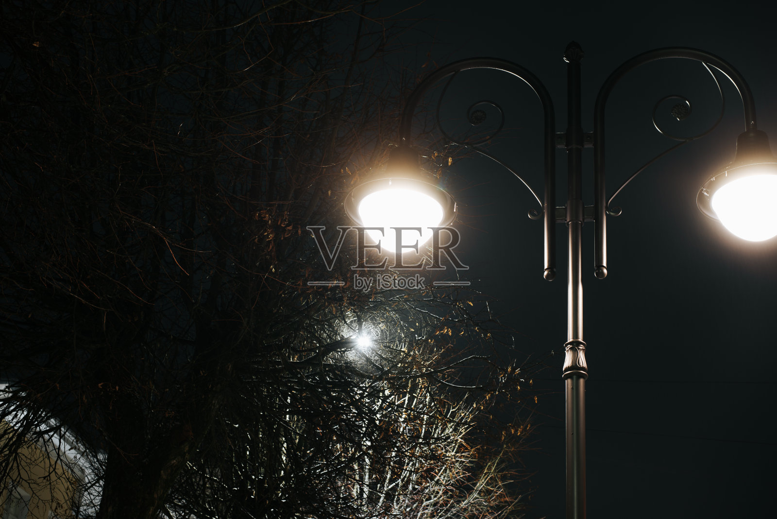 在户外，夜晚用两盏灯点亮复古街灯照片摄影图片