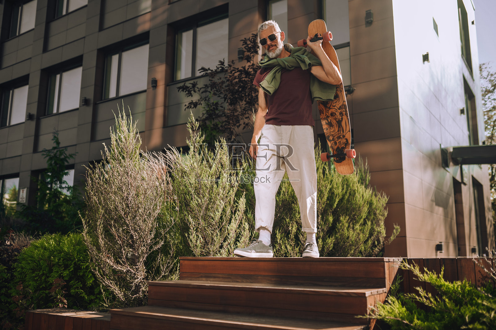 冷静的灰白头发的人滑着滑板下楼照片摄影图片