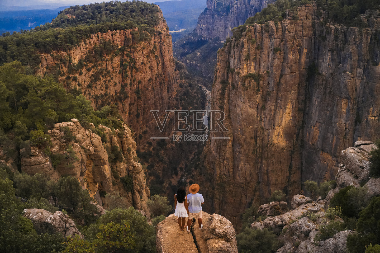 一对游客夫妇在土耳其安塔利亚马纳夫加特塔兹峡谷的悬崖边。灰狗峡谷，智慧谷照片摄影图片