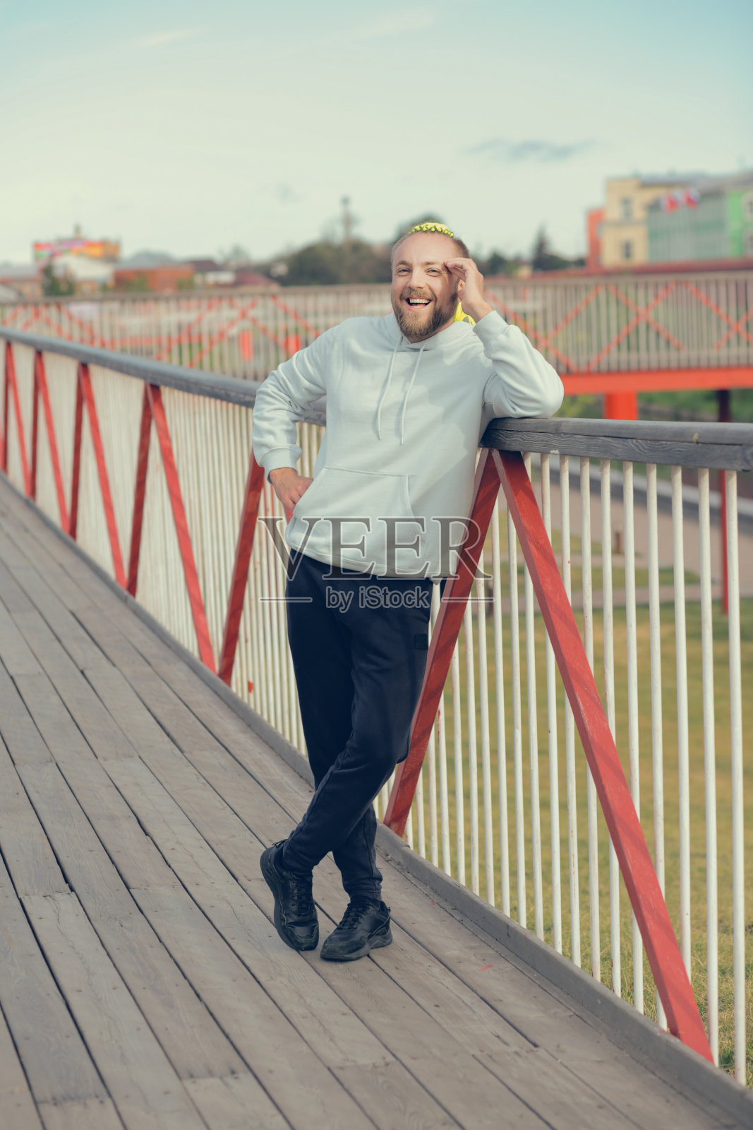 一个留着有趣莫霍克发型的男人站在桥上照片摄影图片