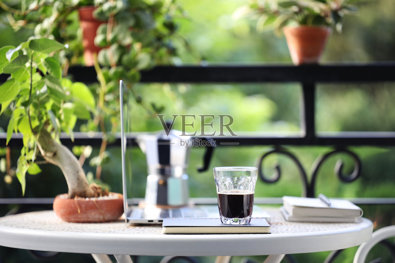 咖啡杯，摩卡壶和笔记本电脑在金属桌上照片摄影图片