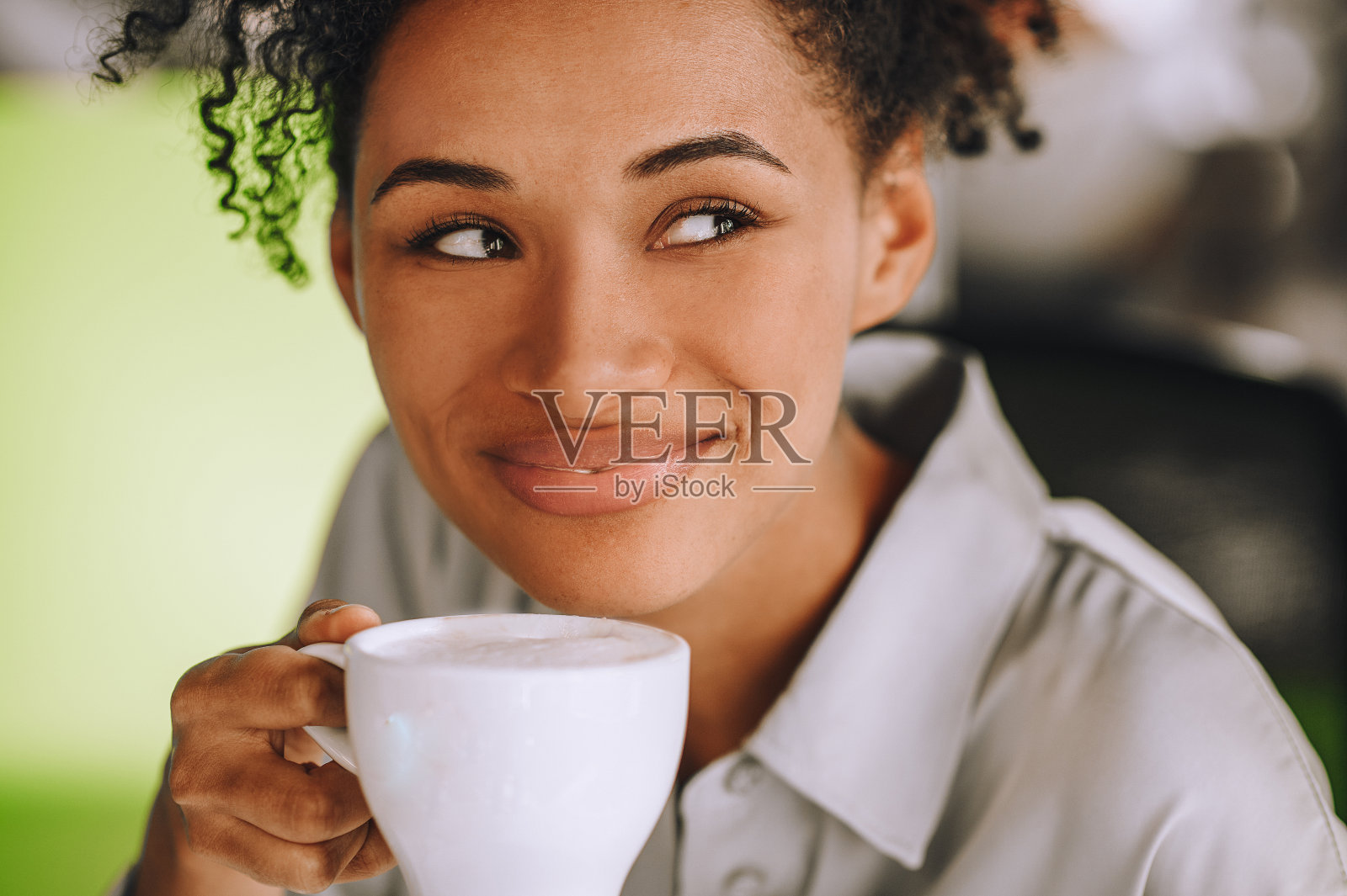 黑皮肤的年轻女子手里拿着一杯咖啡照片摄影图片