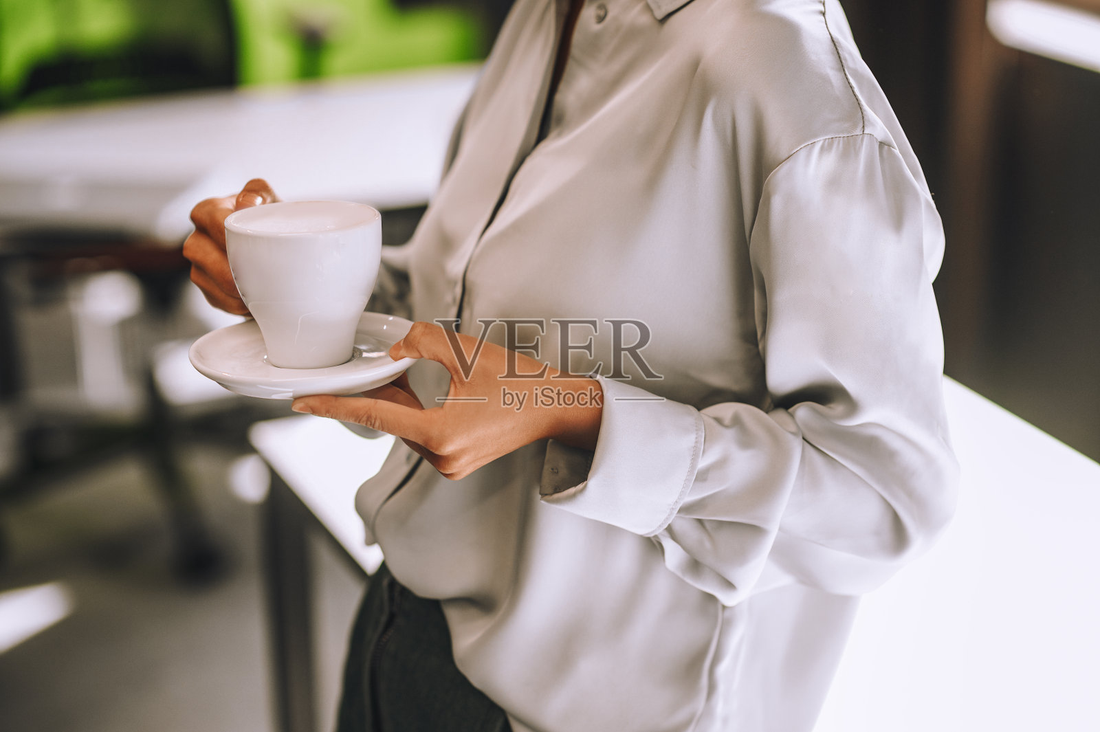 一个手里拿着一杯咖啡的女人的特写照片照片摄影图片