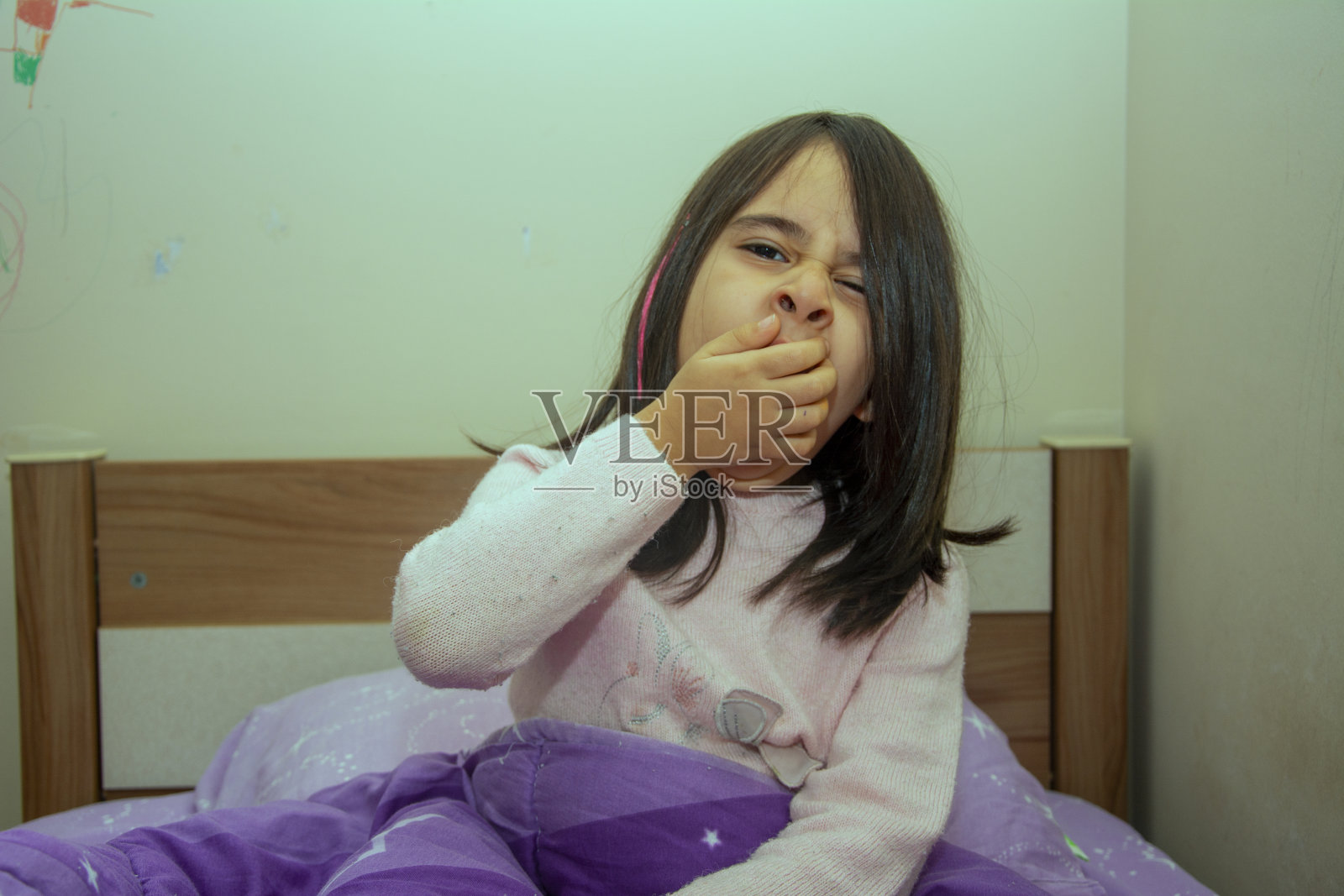 刚叫醒了一个在床上打哈欠的小女孩照片摄影图片