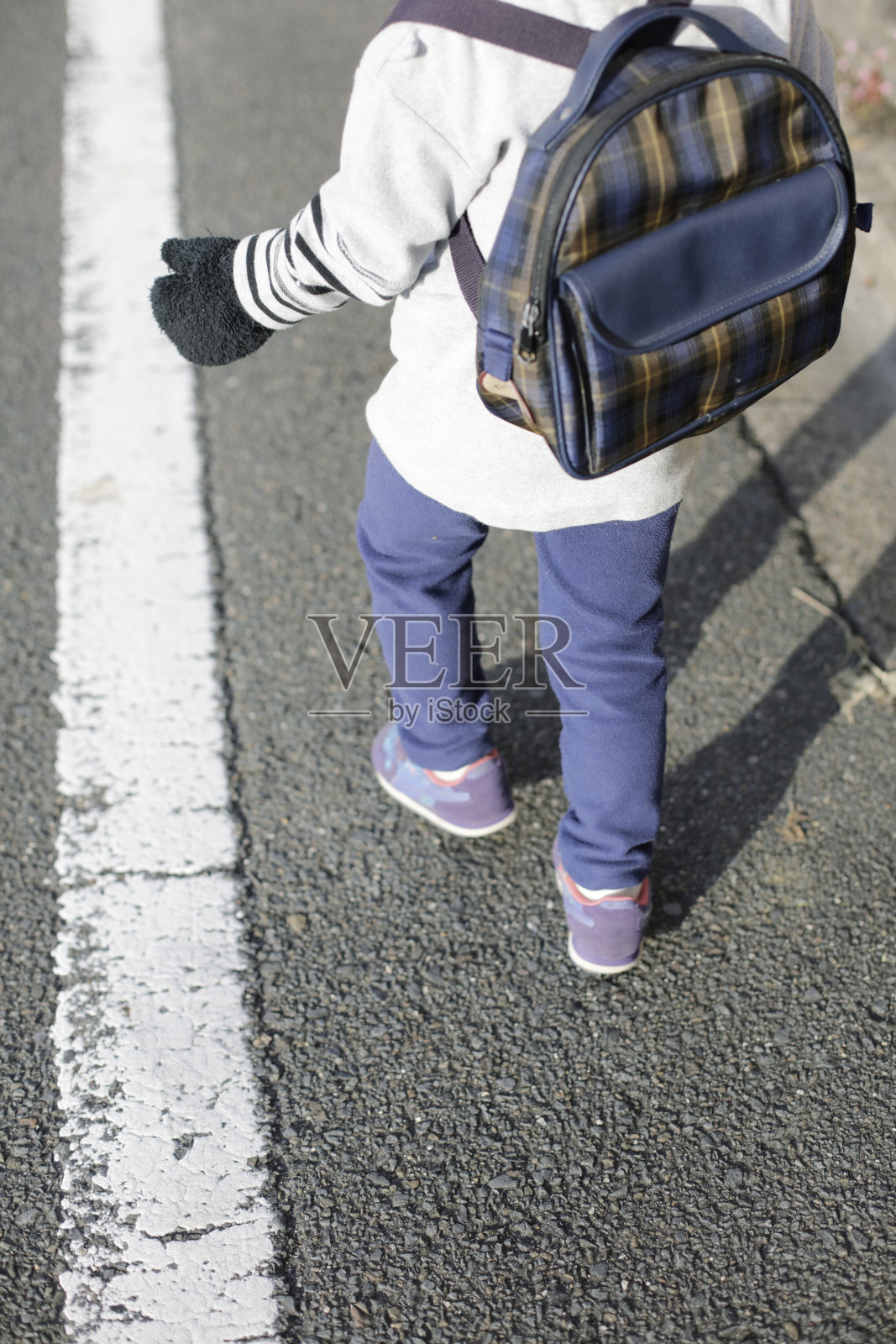 冬天的一天，男孩步行去上学。在日本街头照片摄影图片