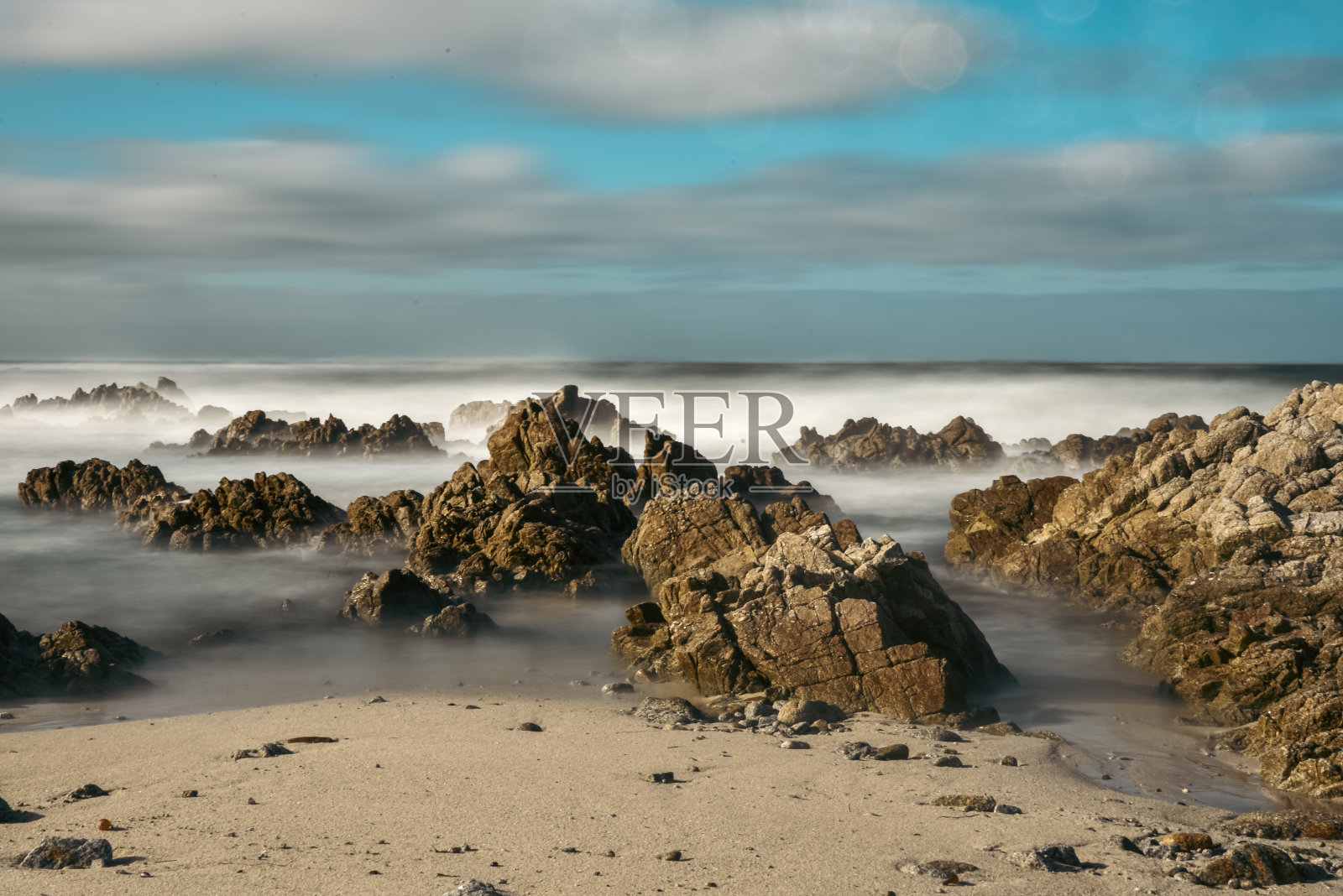 长时间暴露在太平洋波浪在运动蓝色在岩石海岸线照片摄影图片