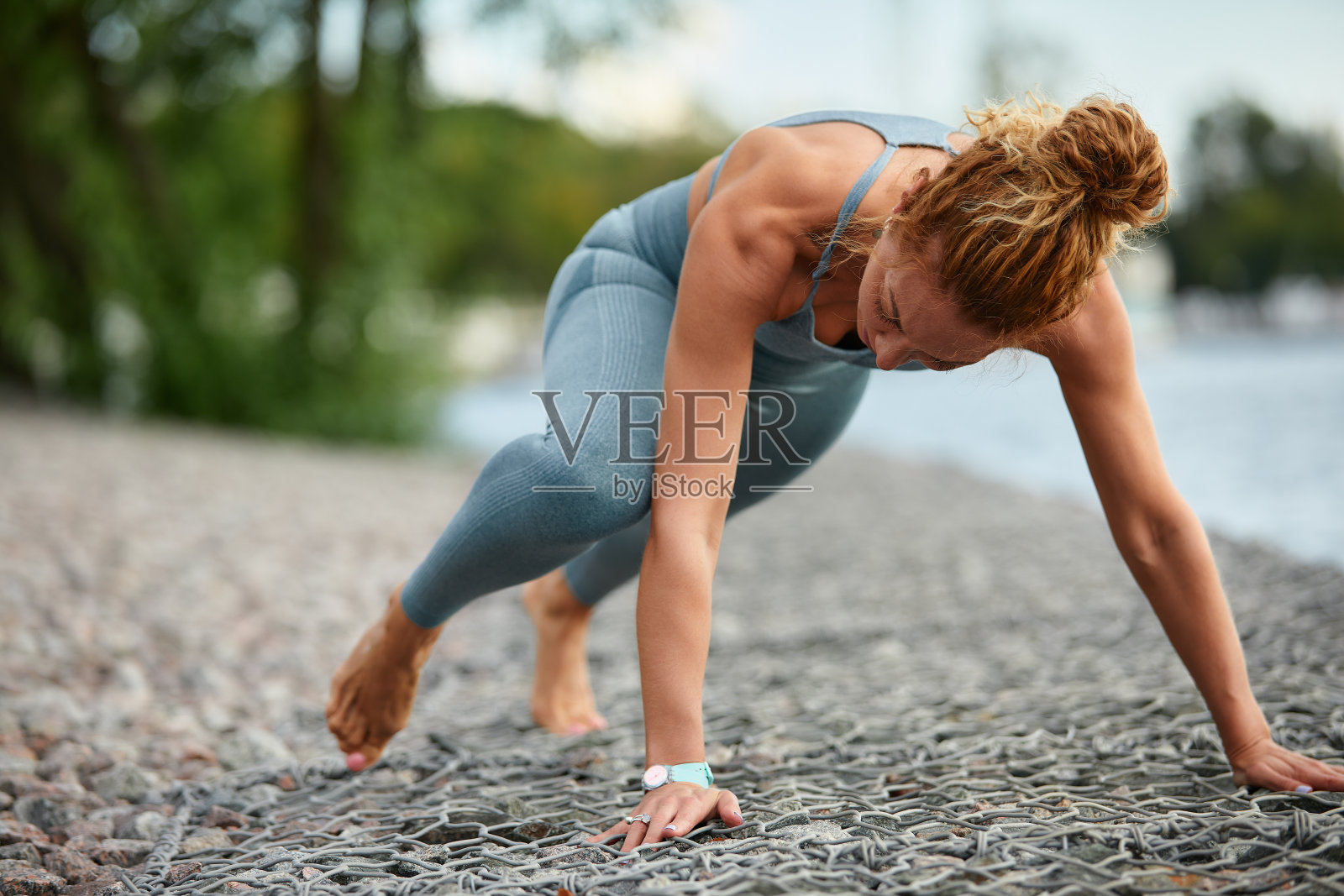金发的年轻女运动员在城市环境的公园里锻炼。有吸引力的运动女人在户外锻炼在早上，拷贝空间。健康,健康的概念照片摄影图片