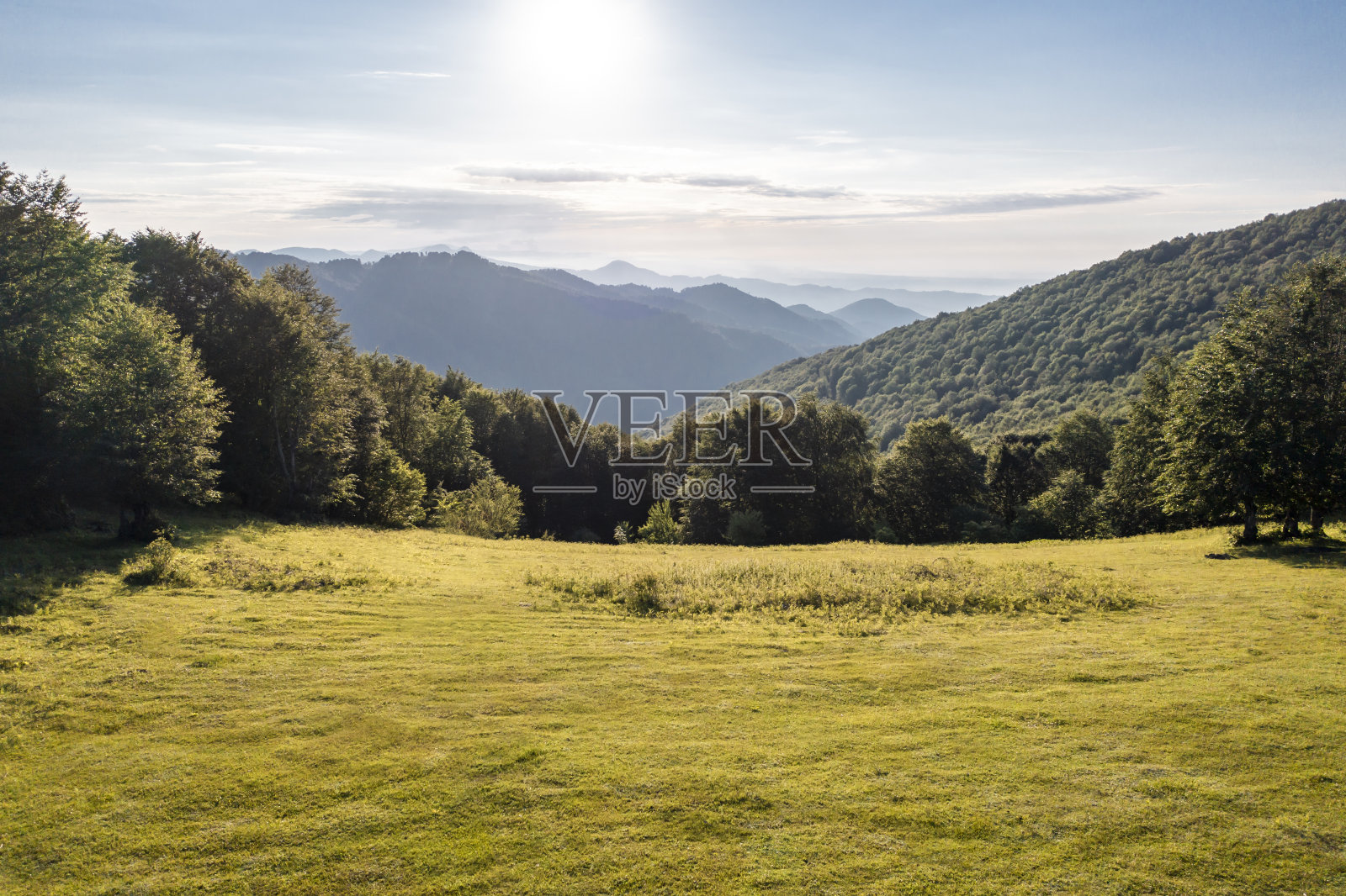 鸟瞰雾蒙蒙的山脉，天空和草地的背景照片摄影图片