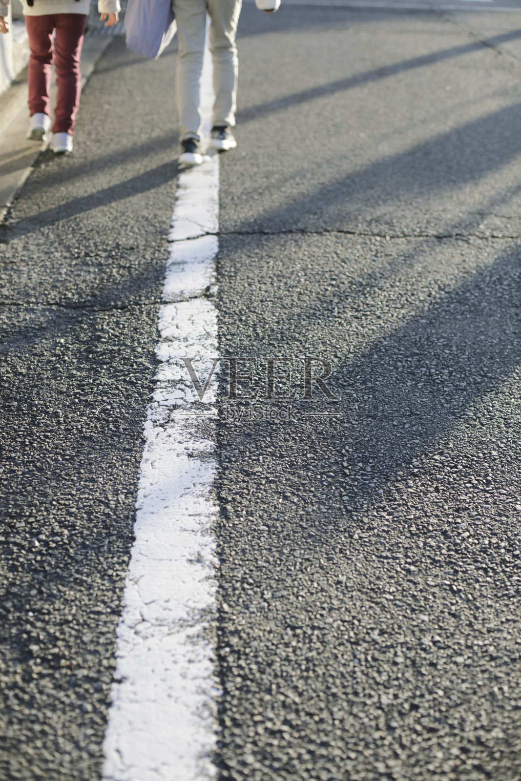 在美丽的秋日阳光明媚的早晨，小学的女孩们走在街上去上学照片摄影图片