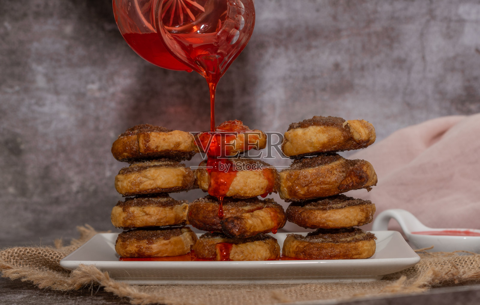 肉桂和糖卷，淋上草莓糖浆照片摄影图片