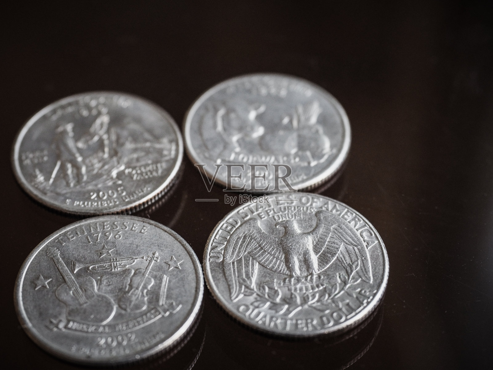 侧面拍摄的4种不同的美元硬币，包括加利福尼亚州，威斯康星州，田纳西州和美国。专注于田纳西币照片摄影图片