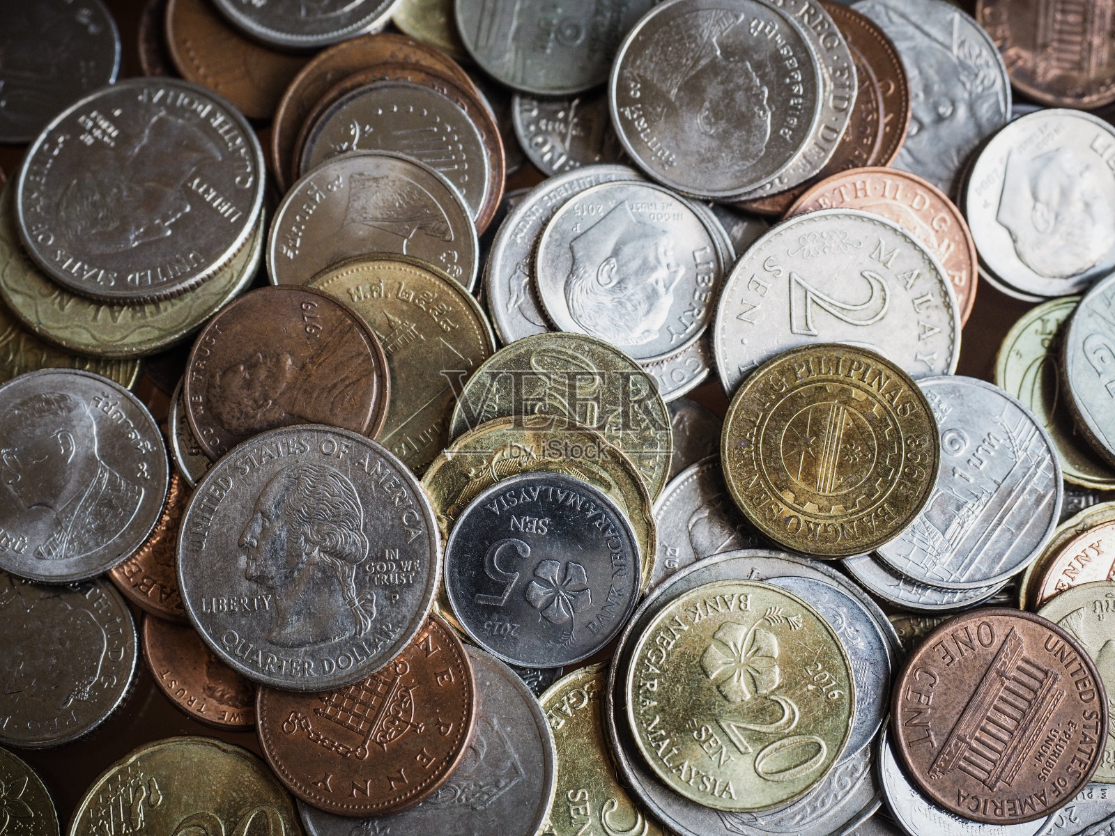 近距离拍摄的各种货币硬币与淡色和暗色调的对比。从上面聚焦的一美元硬币射击照片摄影图片