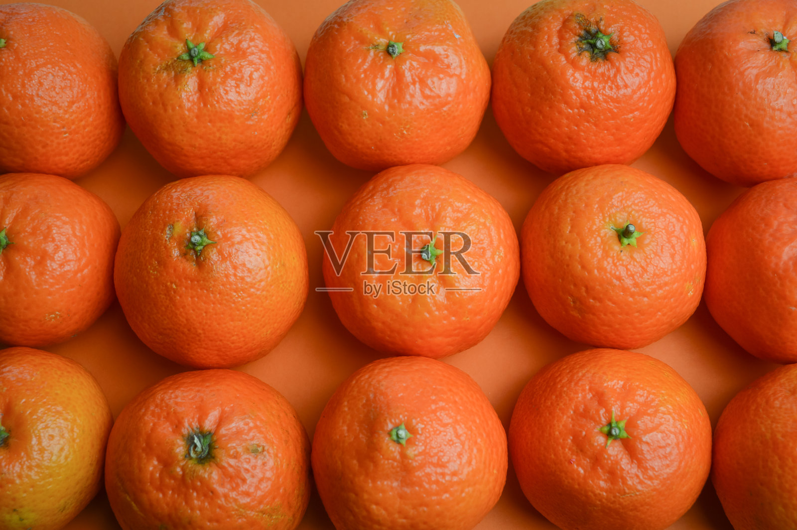 一组有机橘子排列在橙色的纸上照片摄影图片