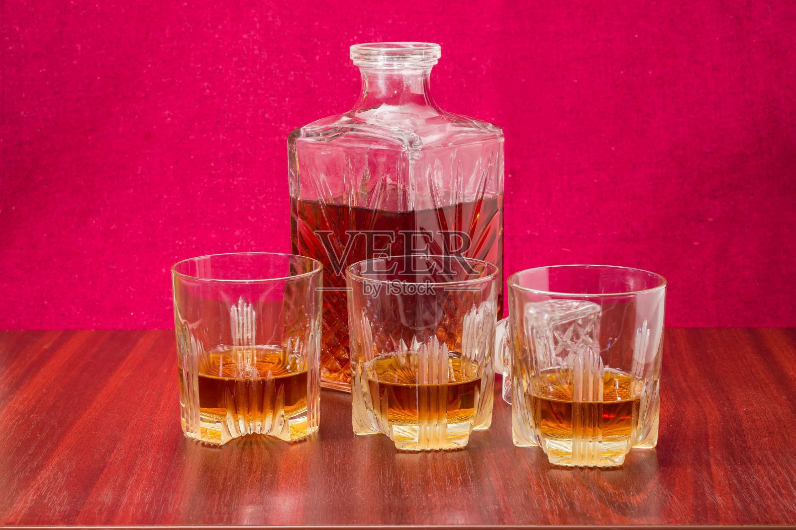 木桌上的三杯威士忌和酒瓶照片摄影图片