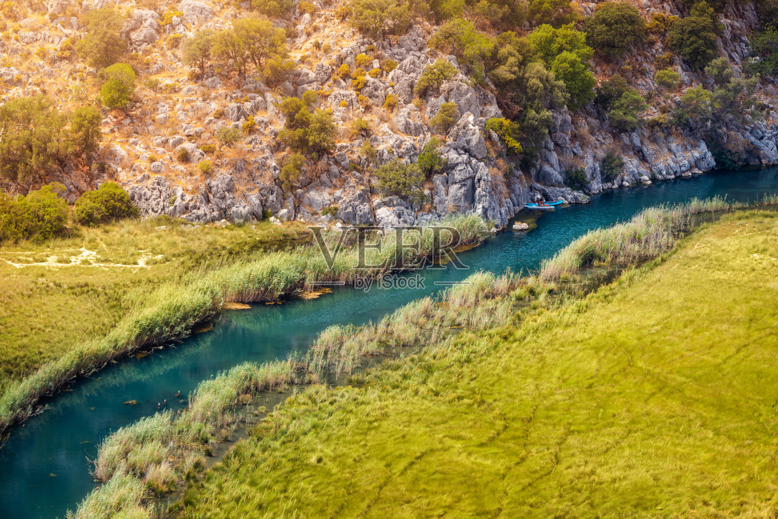 鸟瞰图，一条蜿蜒的河流在沼泽地区的中心，一艘皮艇在小溪上旅行照片摄影图片