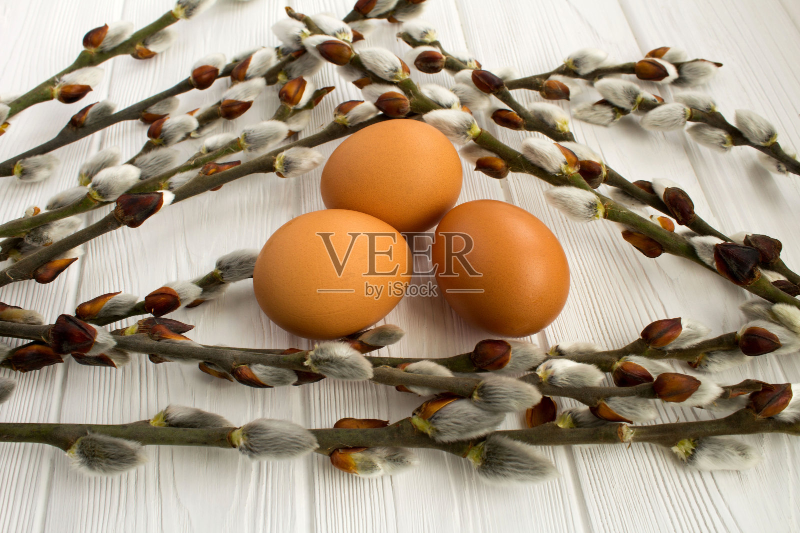 柳条和鸡蛋在白色的木制背景。特写镜头。照片摄影图片