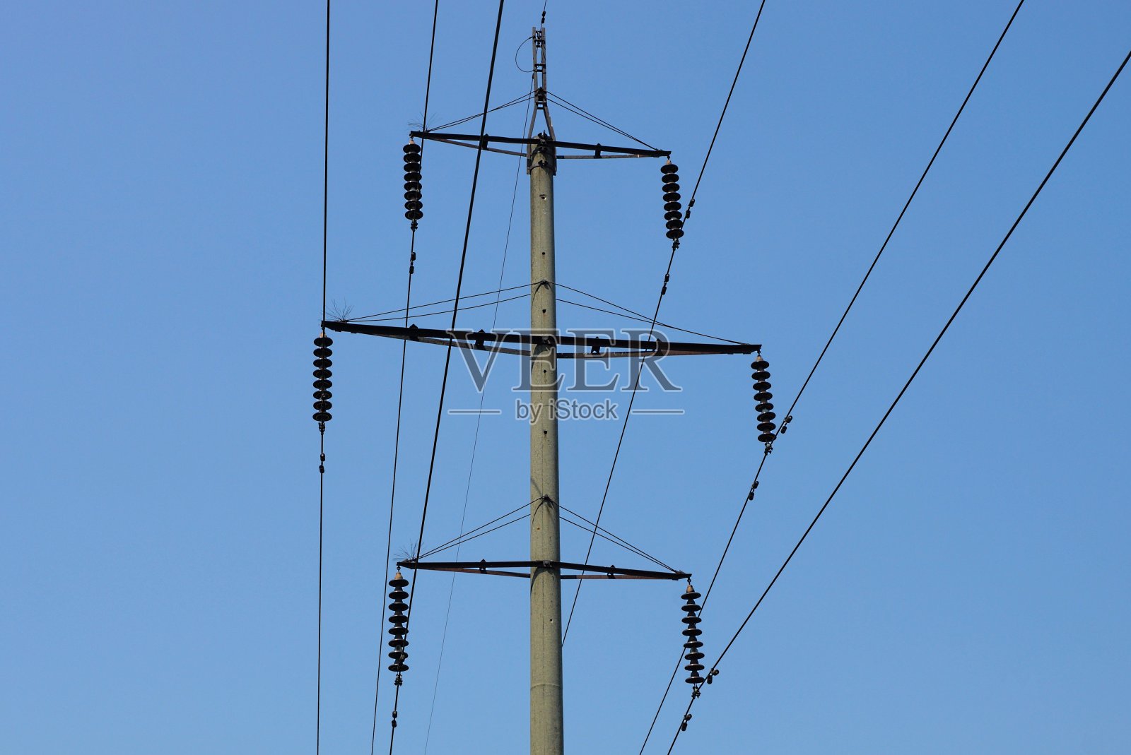 街上有一根高高的灰色混凝土柱子，上面有电线照片摄影图片