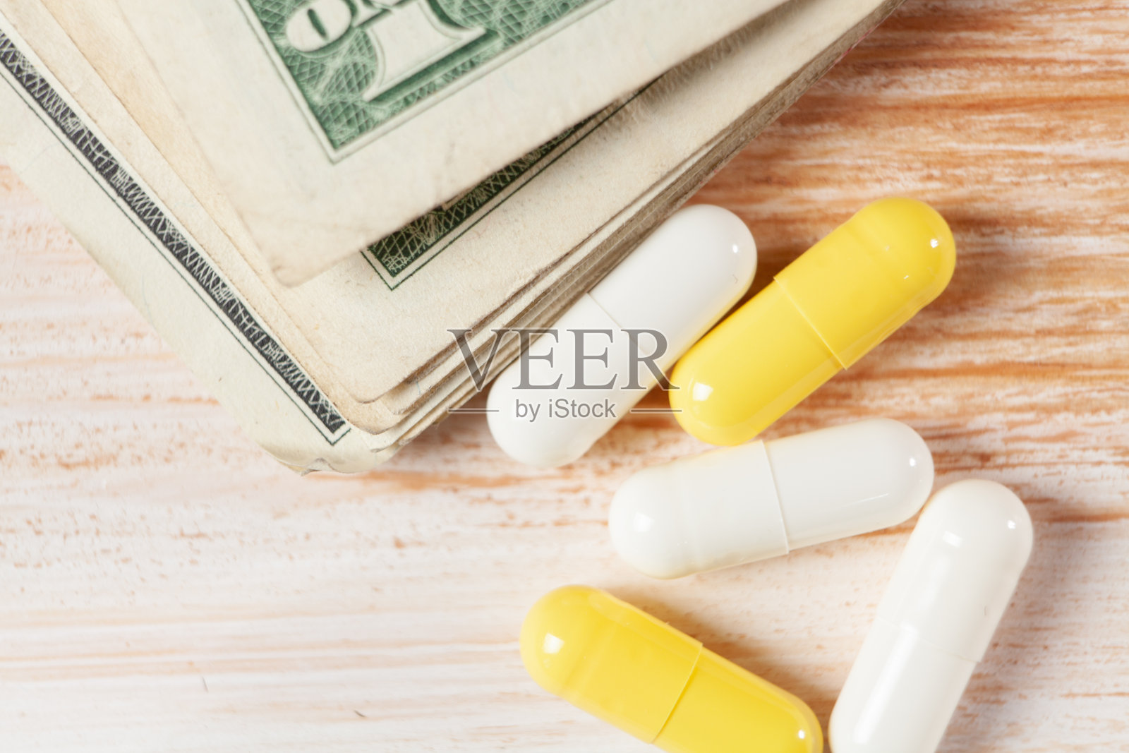 黄色背景上的药片和钱照片摄影图片