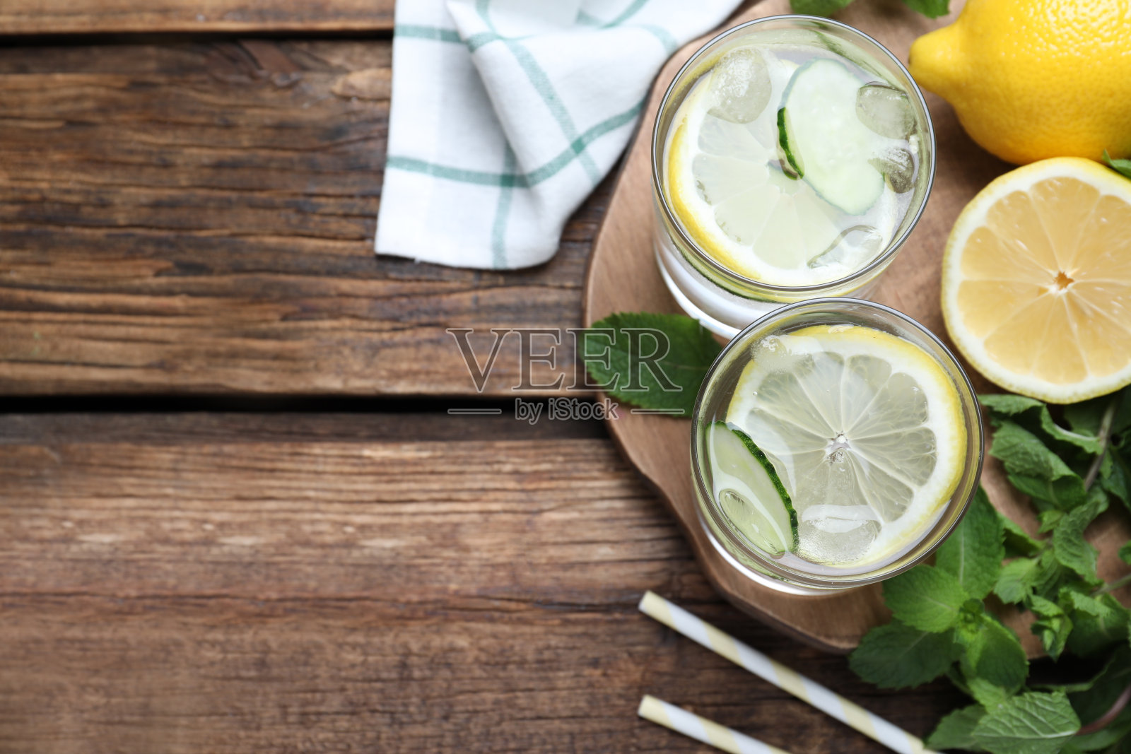 清水与黄瓜，柠檬和薄荷放在木桌上，平放。空间的文本照片摄影图片