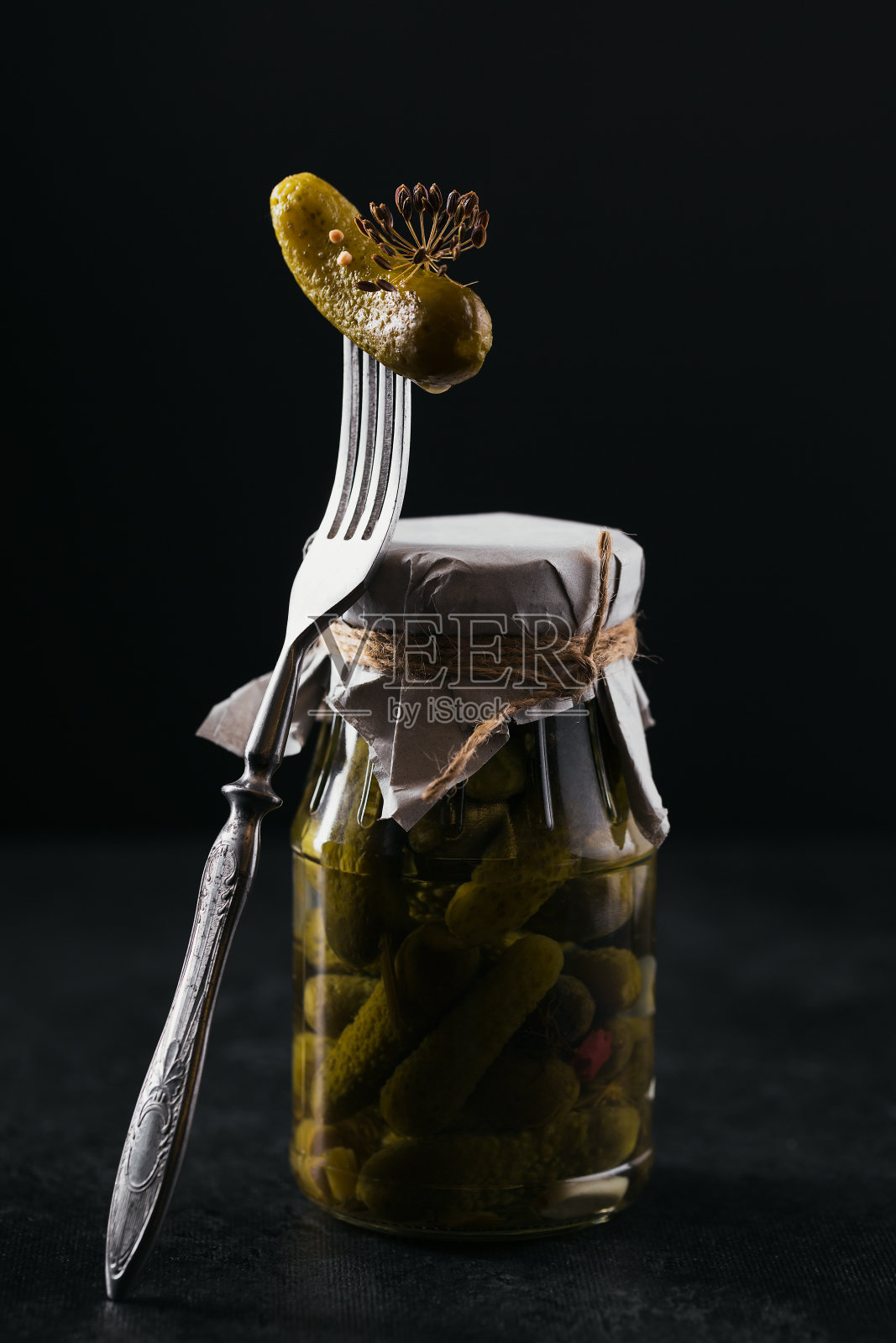 小黄瓜，叉子上的腌黄瓜，黑色背景上的腌蔬菜玻璃罐。清洁饮食，素食理念照片摄影图片